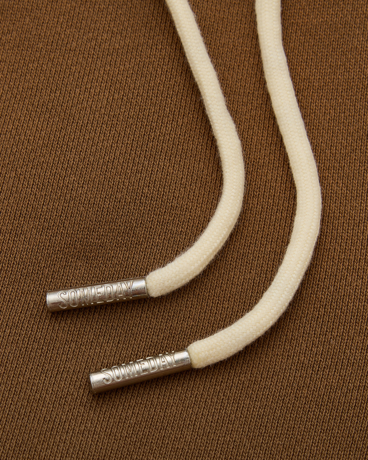 White cord with metal ends on a brown textured background