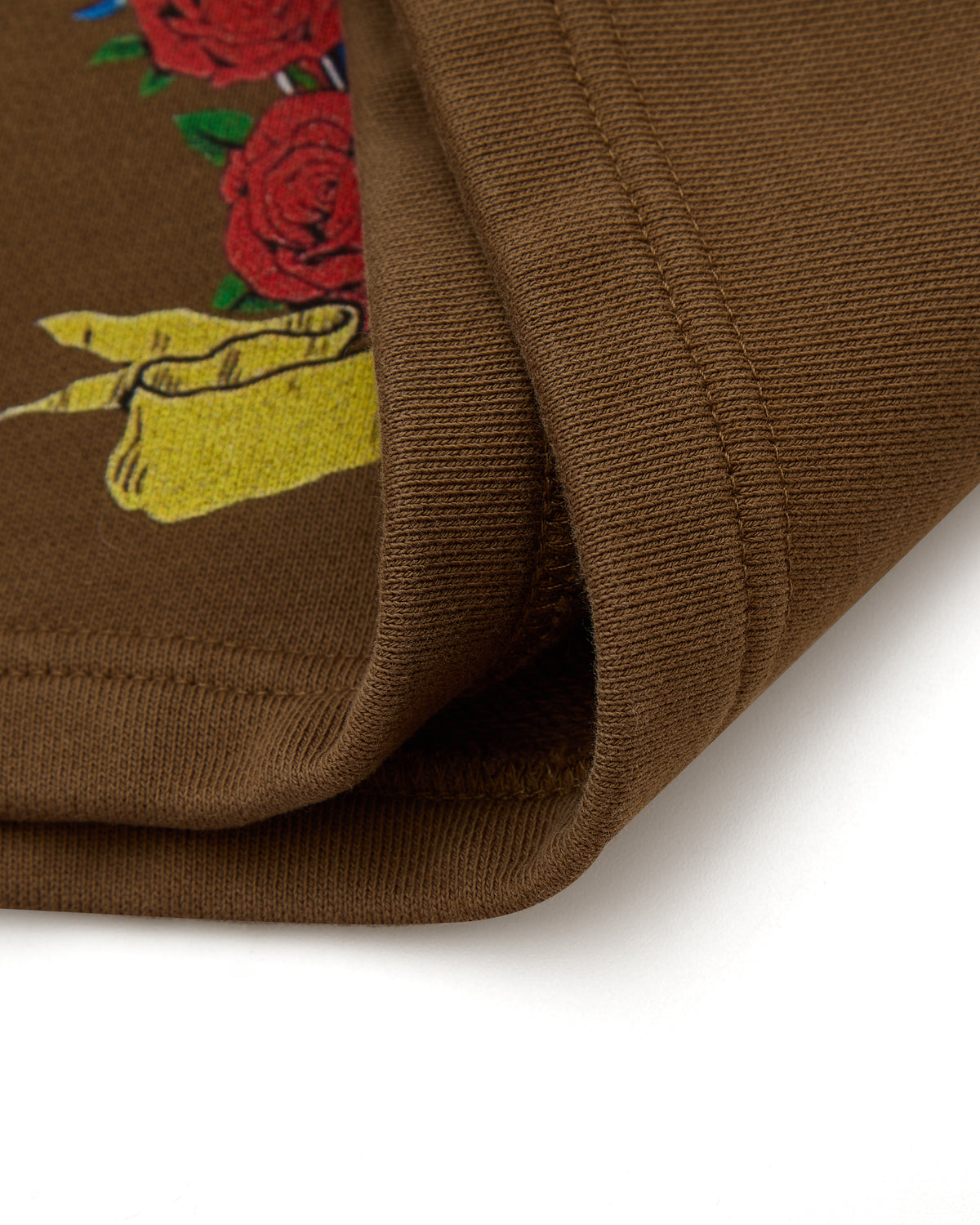 Brown fabric with embroidered design of roses on a white background