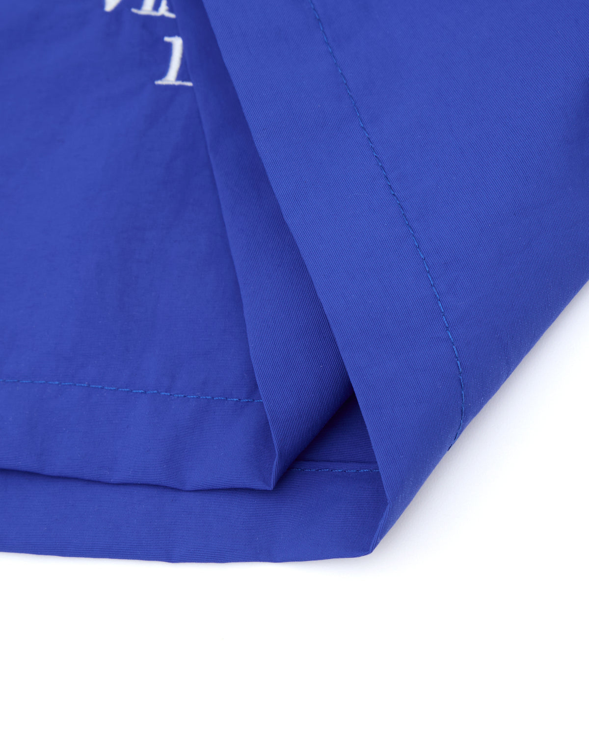 Close-up of blue fabric with a white logo on a white background