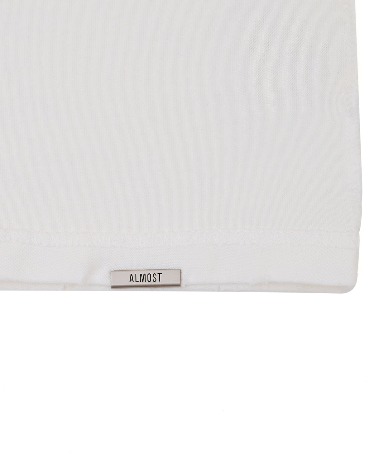 White pillow with 'ALMOST' label on a white background