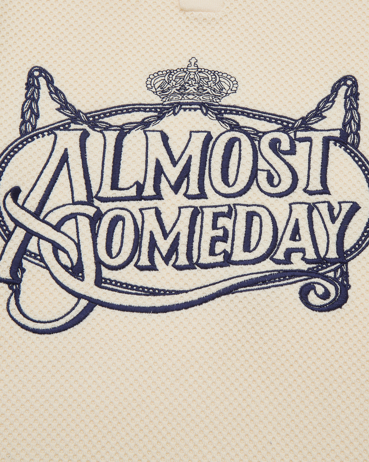 Decorative text 'ALMOST SOMEDAY' with a crown and decorative elements on a textured beige background.