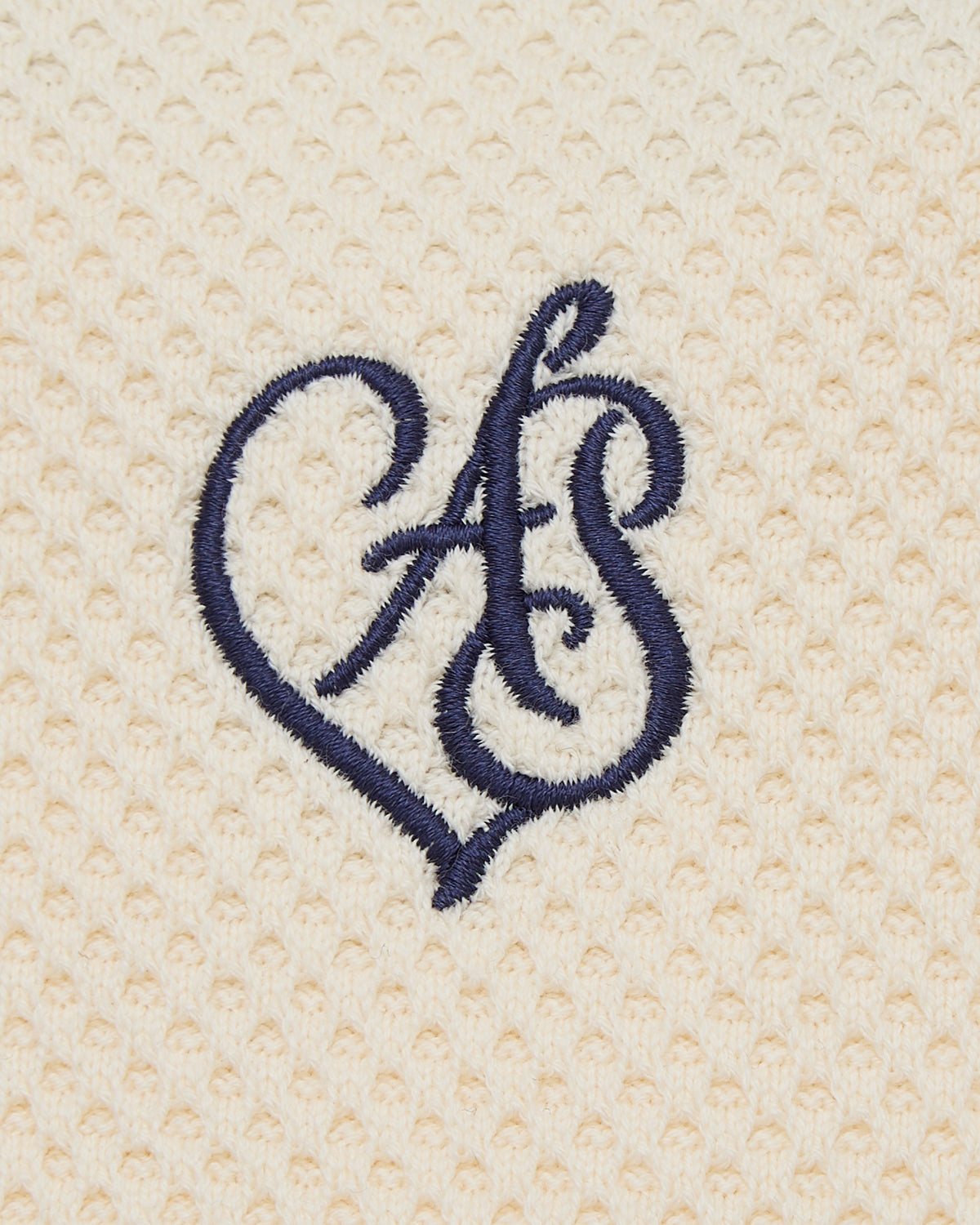 Navy blue embroidered monogram on beige textured fabric