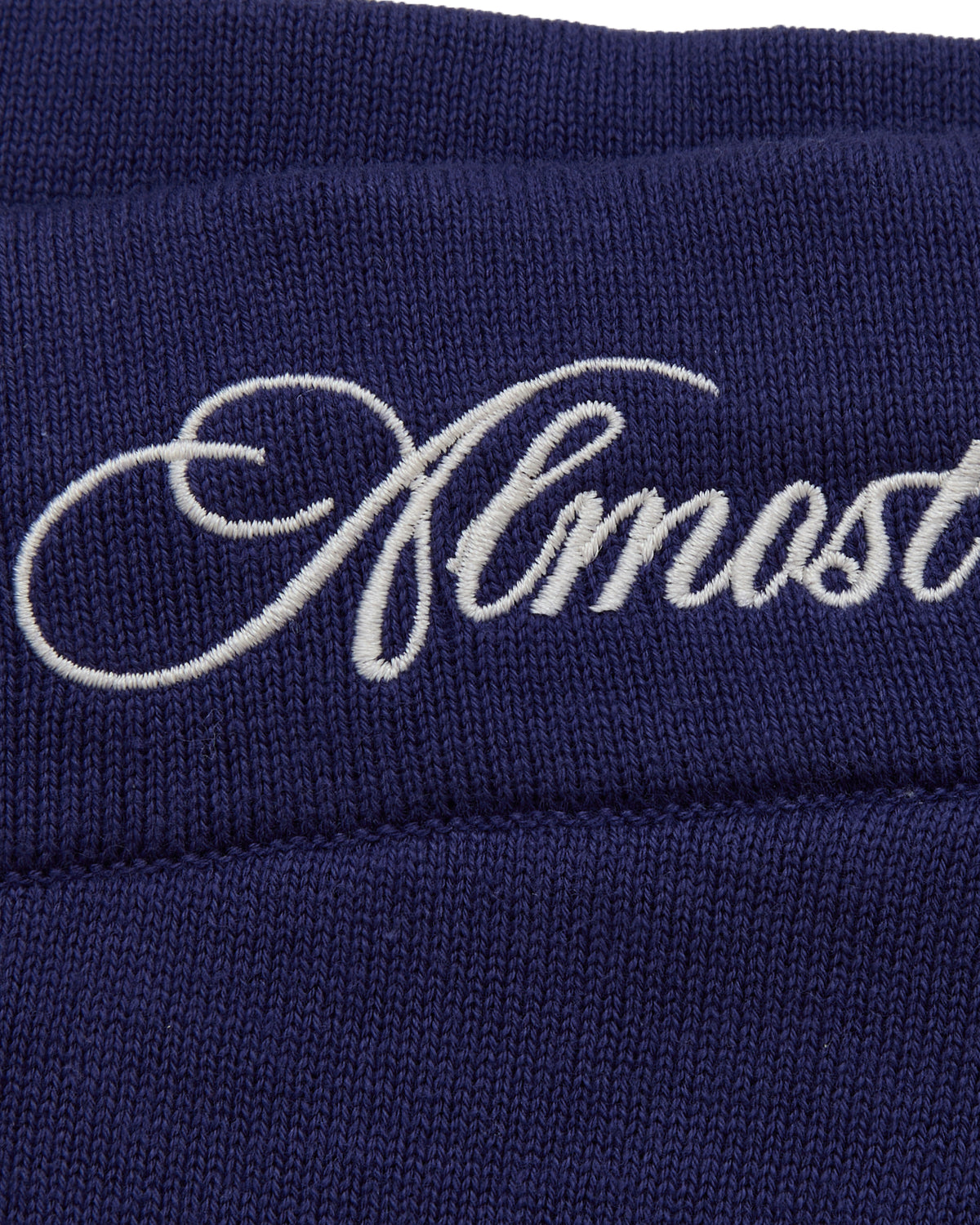 Navy blue fabric with 'Almost' embroidered in white thread