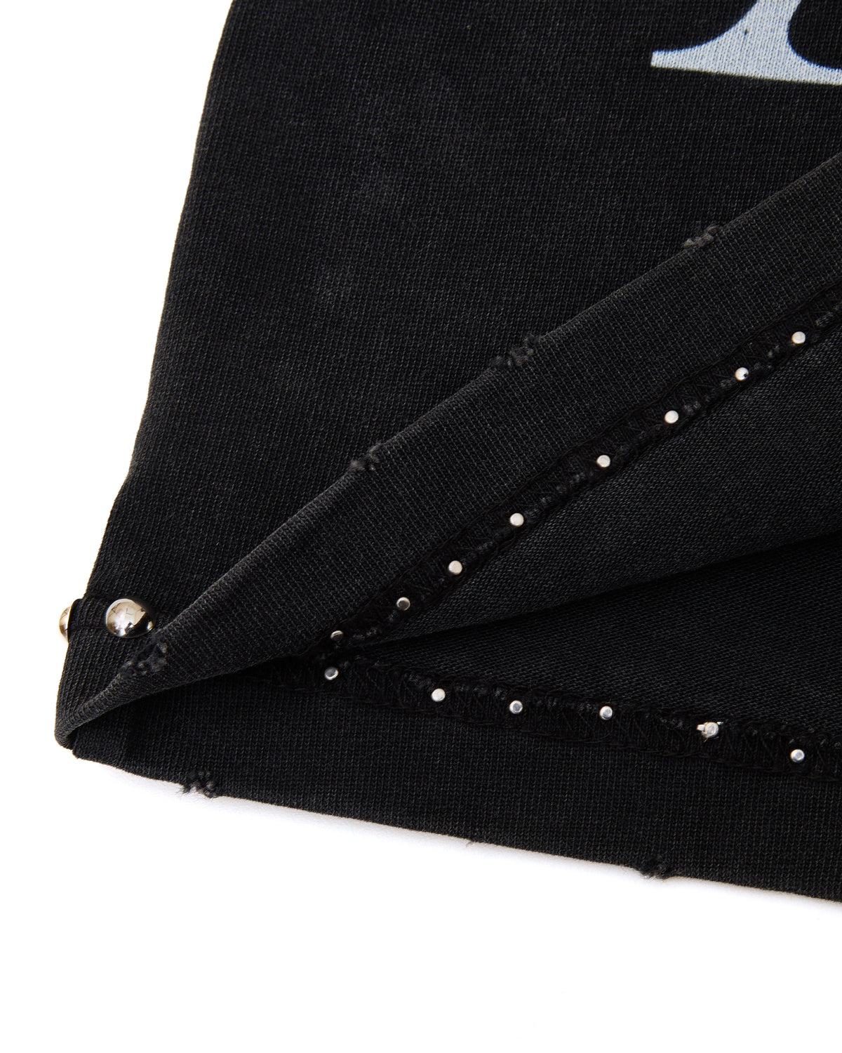 Close-up of a black fabric with silver studs on a white background