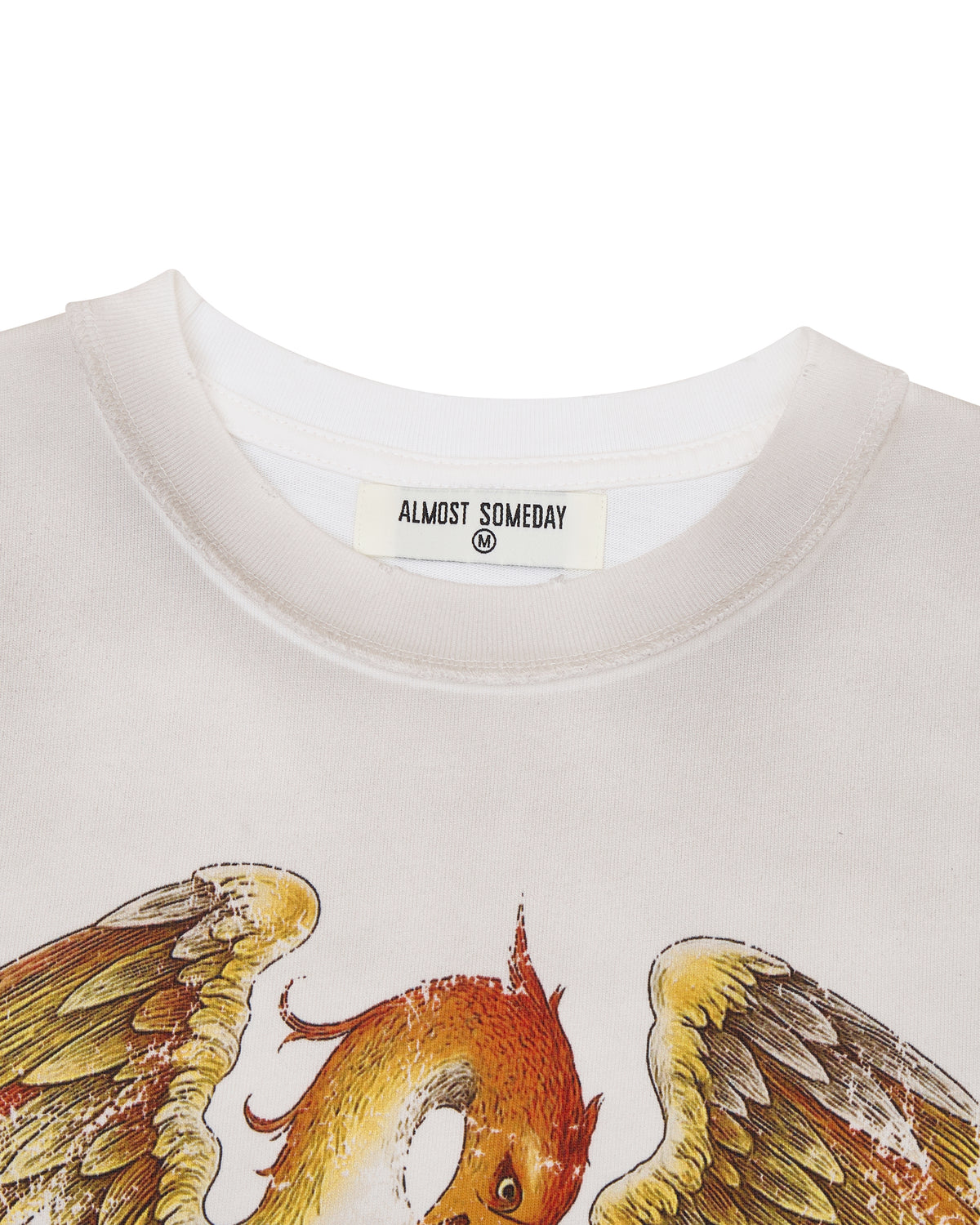 Close-up of a shirt with a dragon design and 'Almost Someday' label.