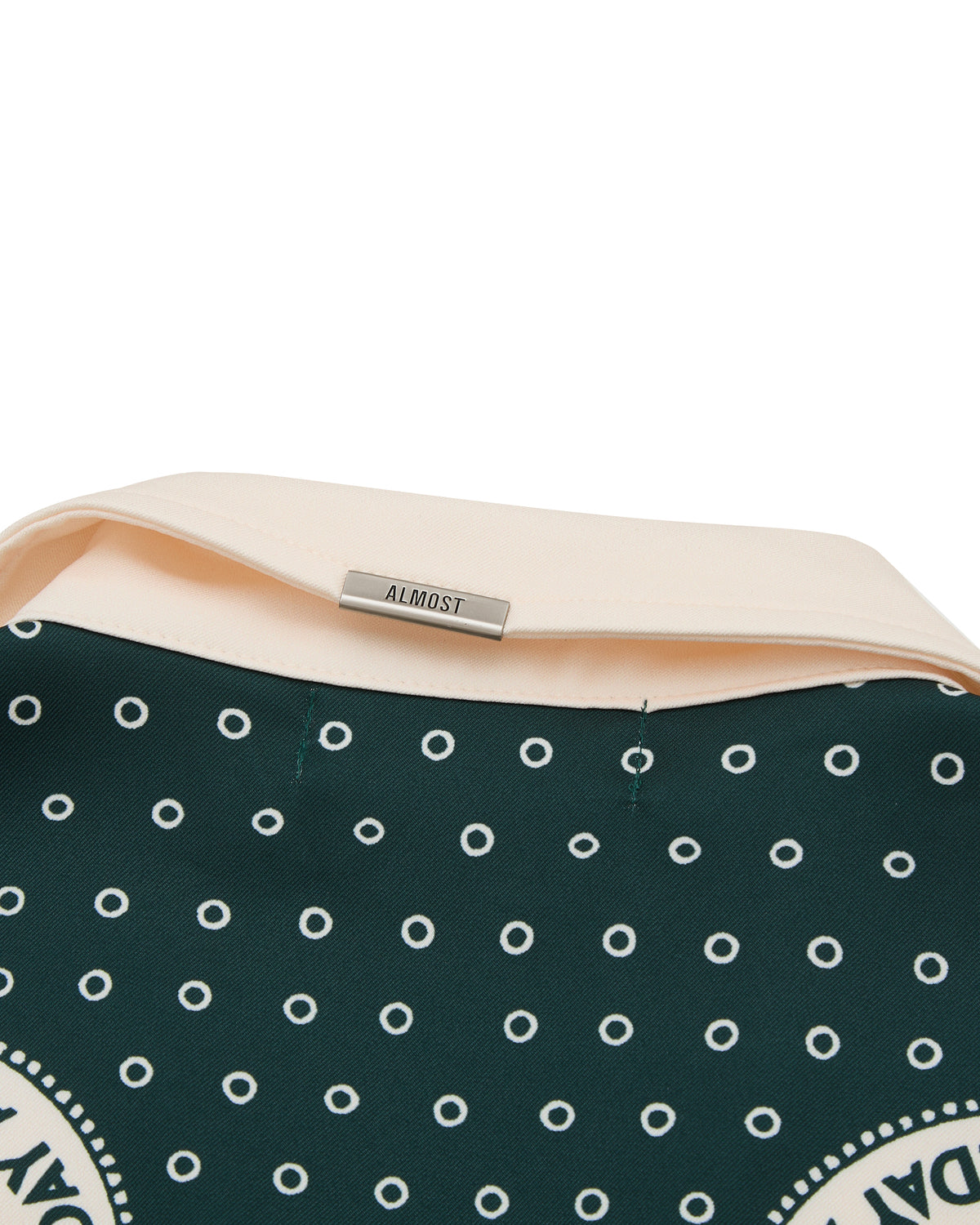 Polka dot short with 'ALMOST' metal detailing on a white background