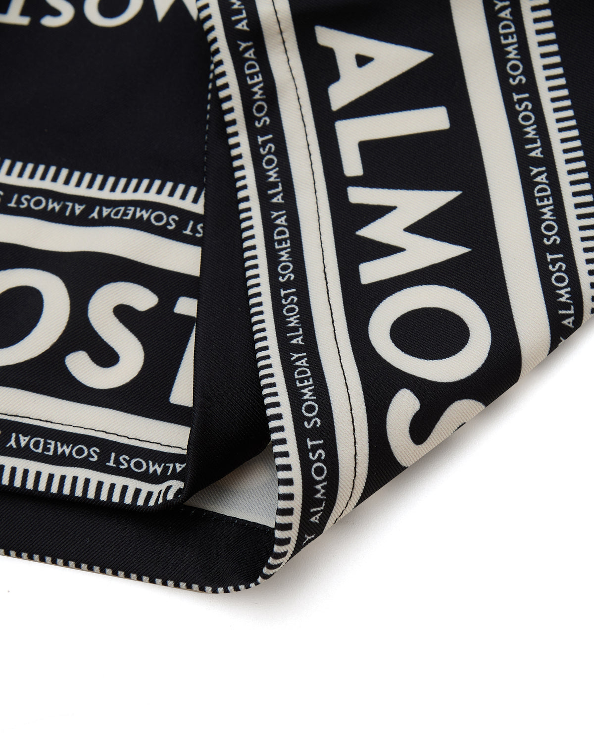 Black fabric with white text pattern on a white background