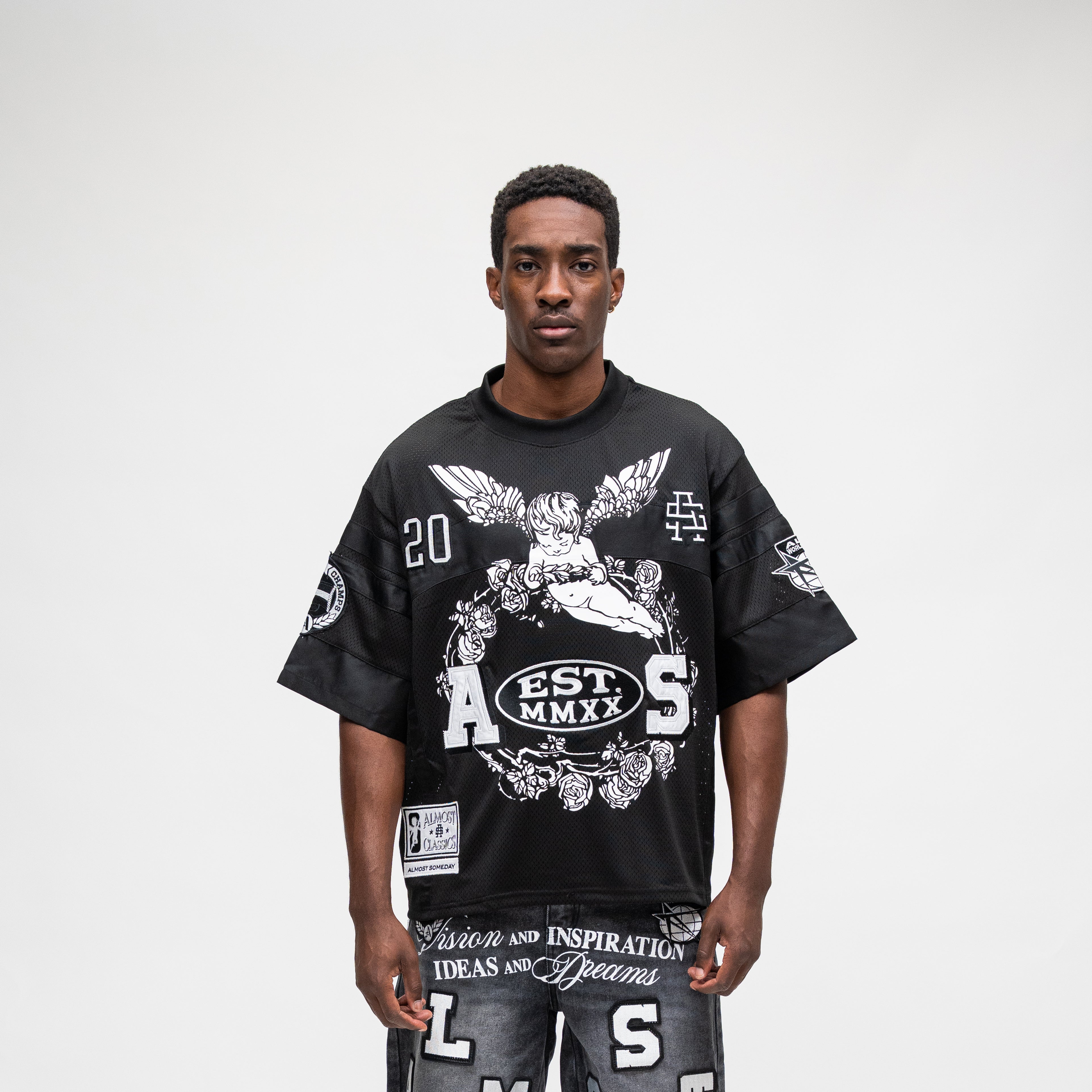 ALMOST SOMEDAY Letterman Jersey Top in Black, front view with cherub angel graphic, EST. MMXX badge, A S block letters, and number 20 detail