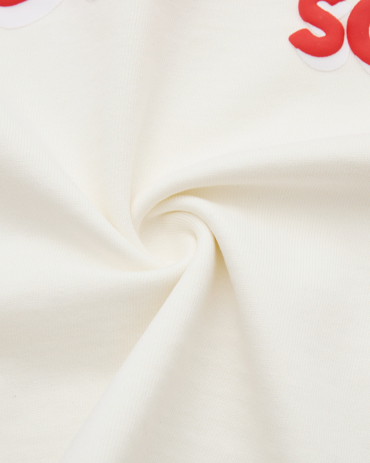Close-up of cream fabric with red text on a white background