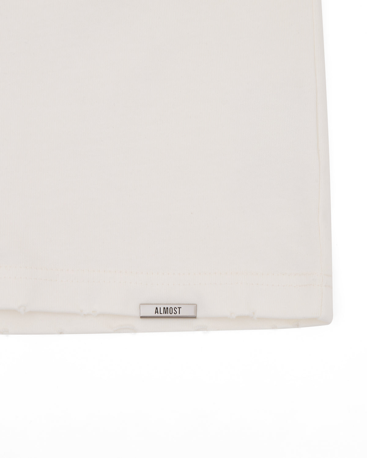 White pillow with 'ALMOST' label on a white background