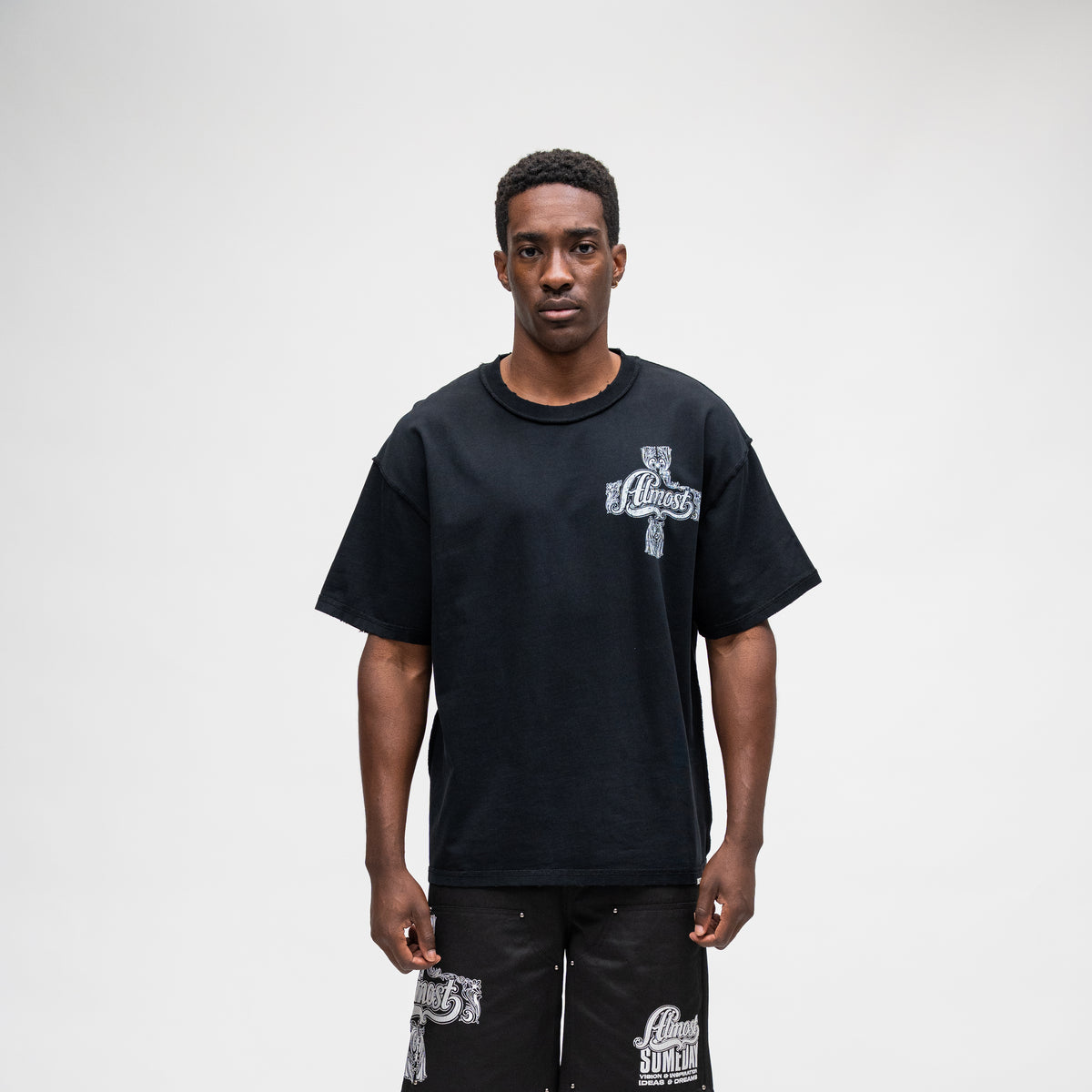 ALMOST SOMEDAY Vision Tee in Black, front view with ornate cross graphic on left chest