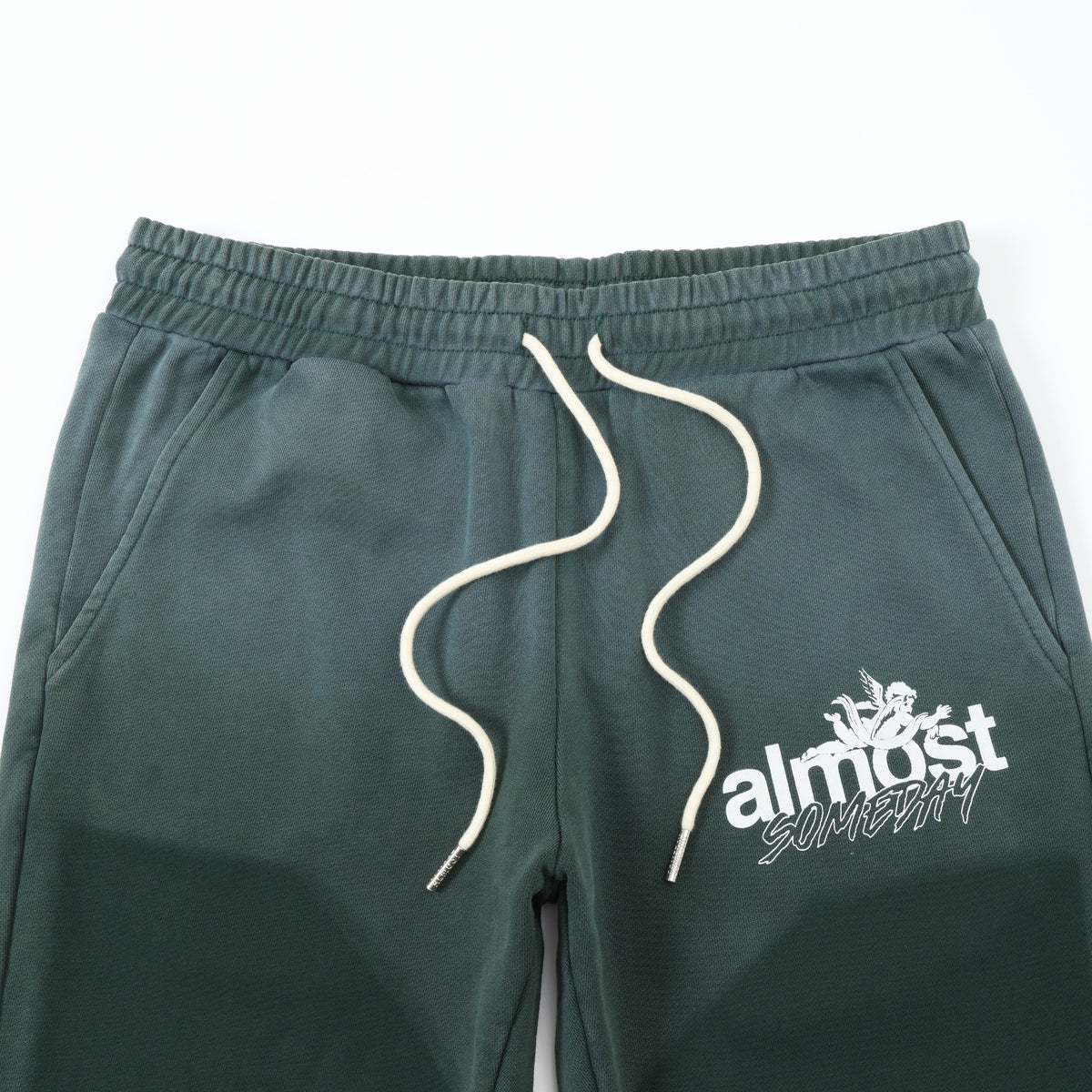 Enemies Flare Bottoms – Green – Close-up of elastic waistband, white drawstrings, angled pockets, and white thigh logo
