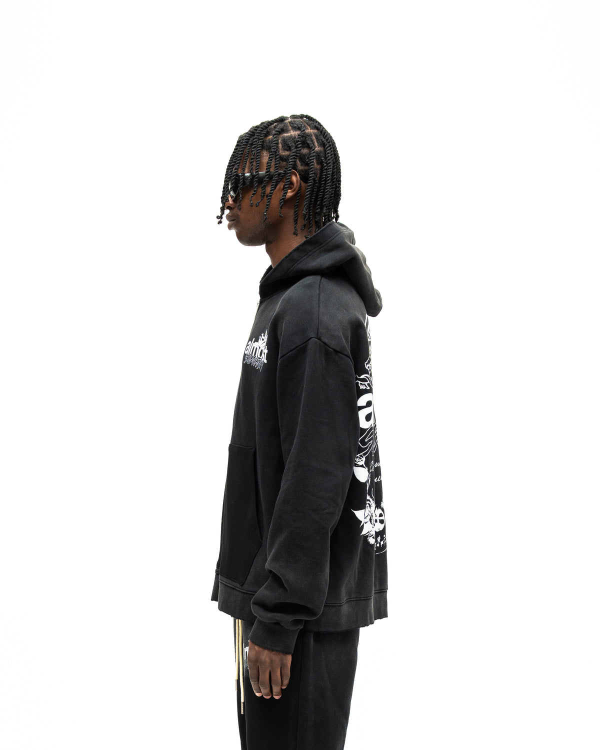 Enemies Zip Hoodie – Black – Side view on model showing hood, long sleeves, and partial back graphic