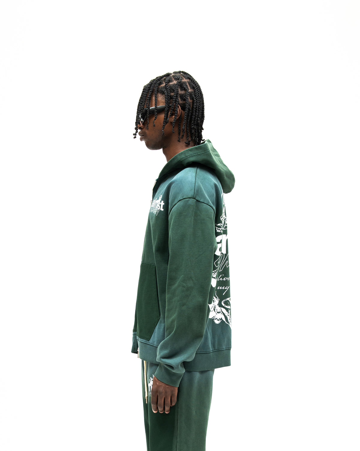 Enemies Zip Hoodie – Green – Side view on model showing hood, long sleeves, and partial white back graphic