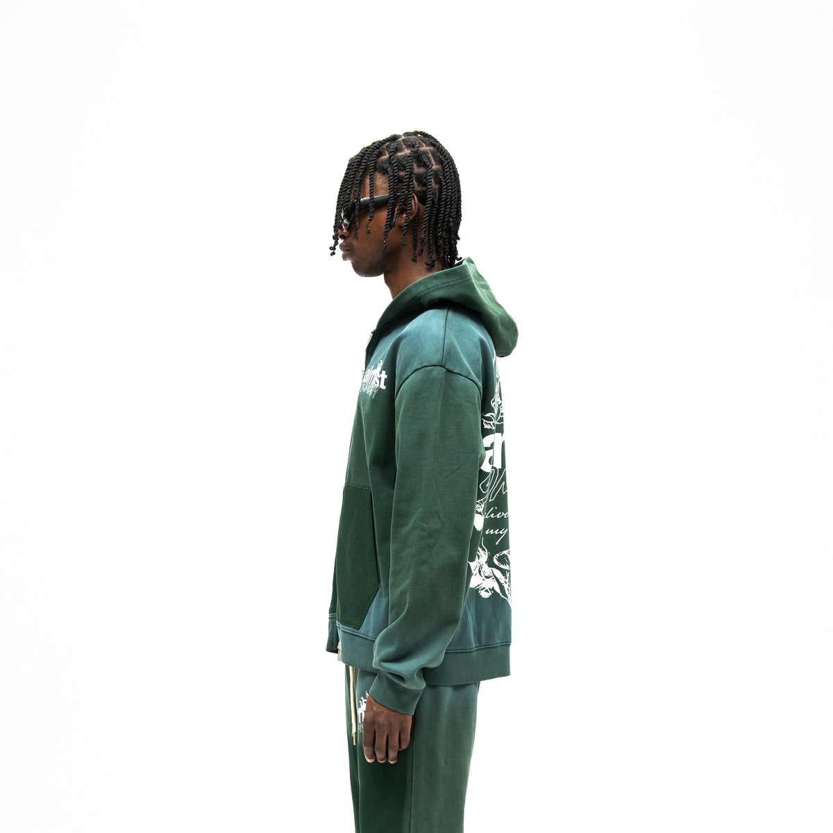 Enemies Zip Hoodie – Green – Side view on model showing hood, long sleeves, and partial white back graphic