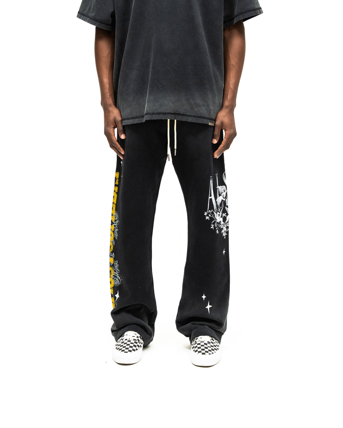 League Flare Sweatpants – Black – Front view on model styled with a tee, showing white drawstrings and flared graphic sweatpants