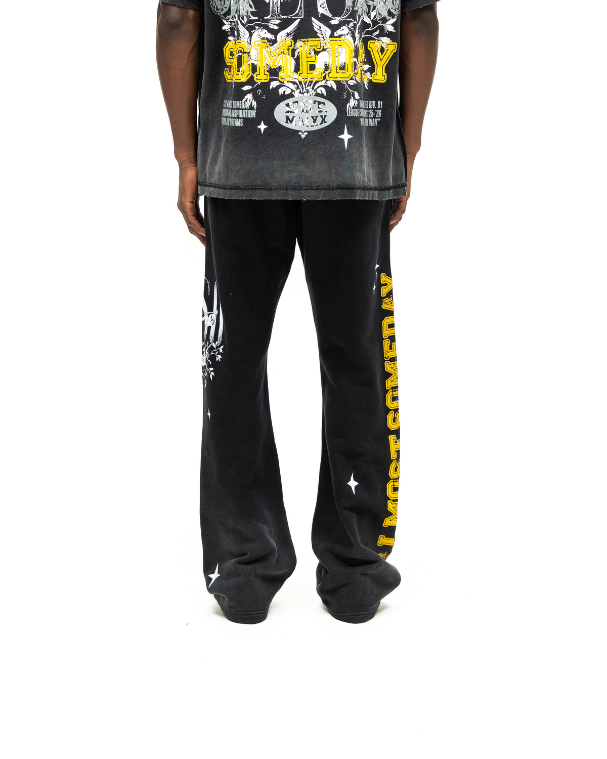 League Flare Sweatpants – Black – Back view on model styled with a tee, showing flared legs and yellow side lettering