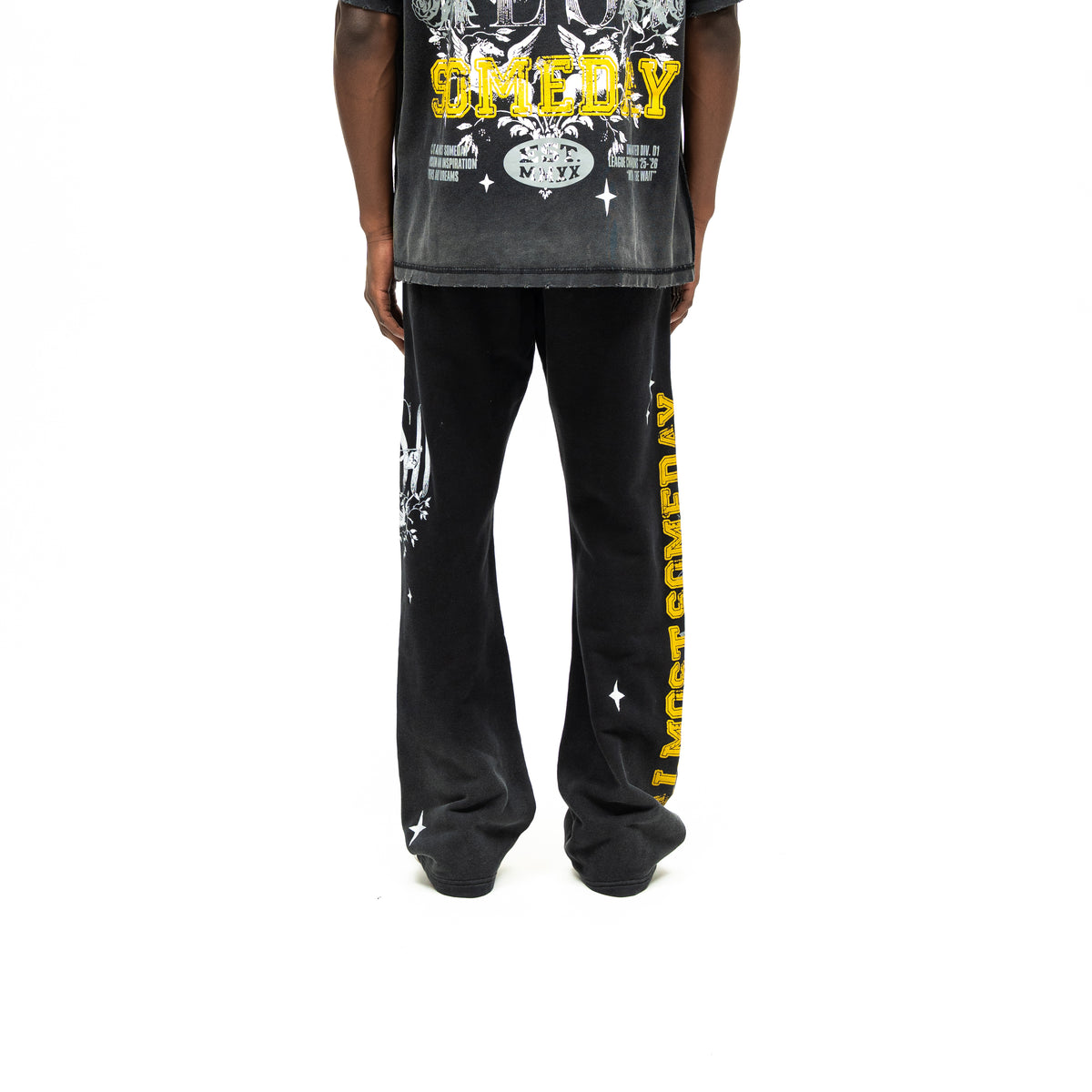 League Flare Sweatpants – Black – Back view on model styled with a tee, showing flared legs and yellow side lettering