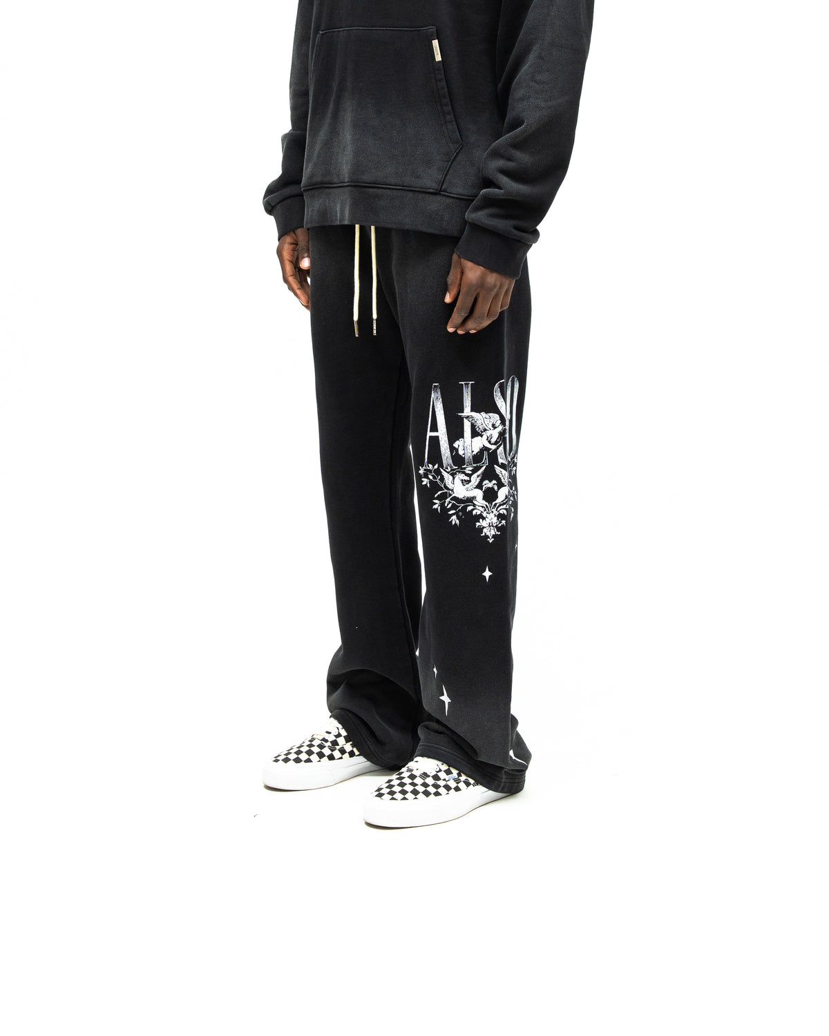 League Flare Sweatpants – Black – Three-quarter front view on model styled with a hoodie, showing white leg graphic and flared hems