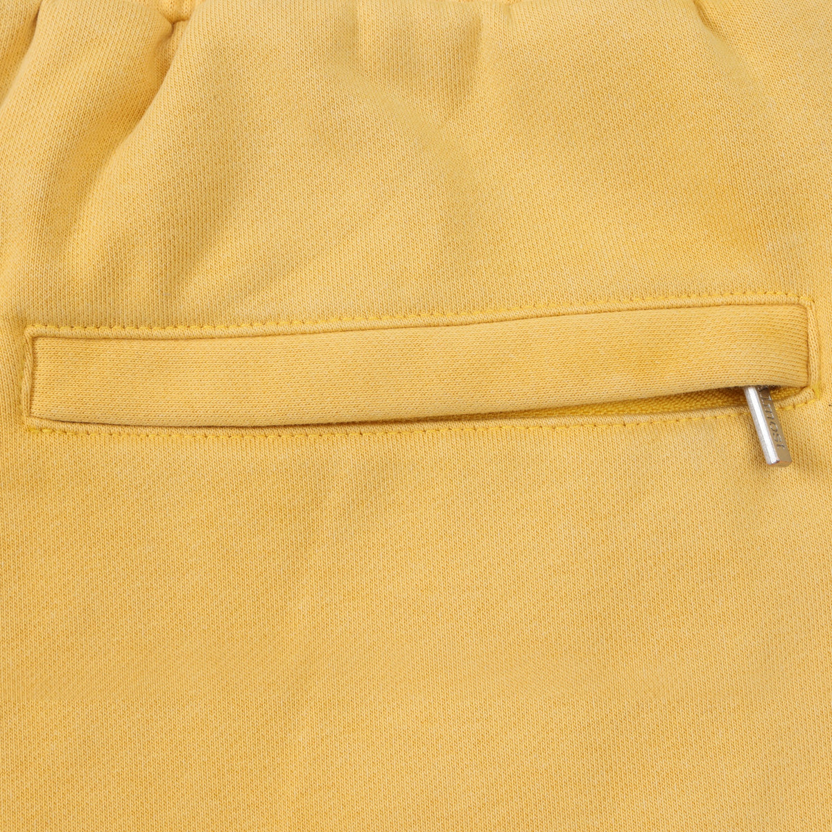 League Flare Sweatpants – Yellow – Close-up of zippered back pocket with silver-tone zipper pull
