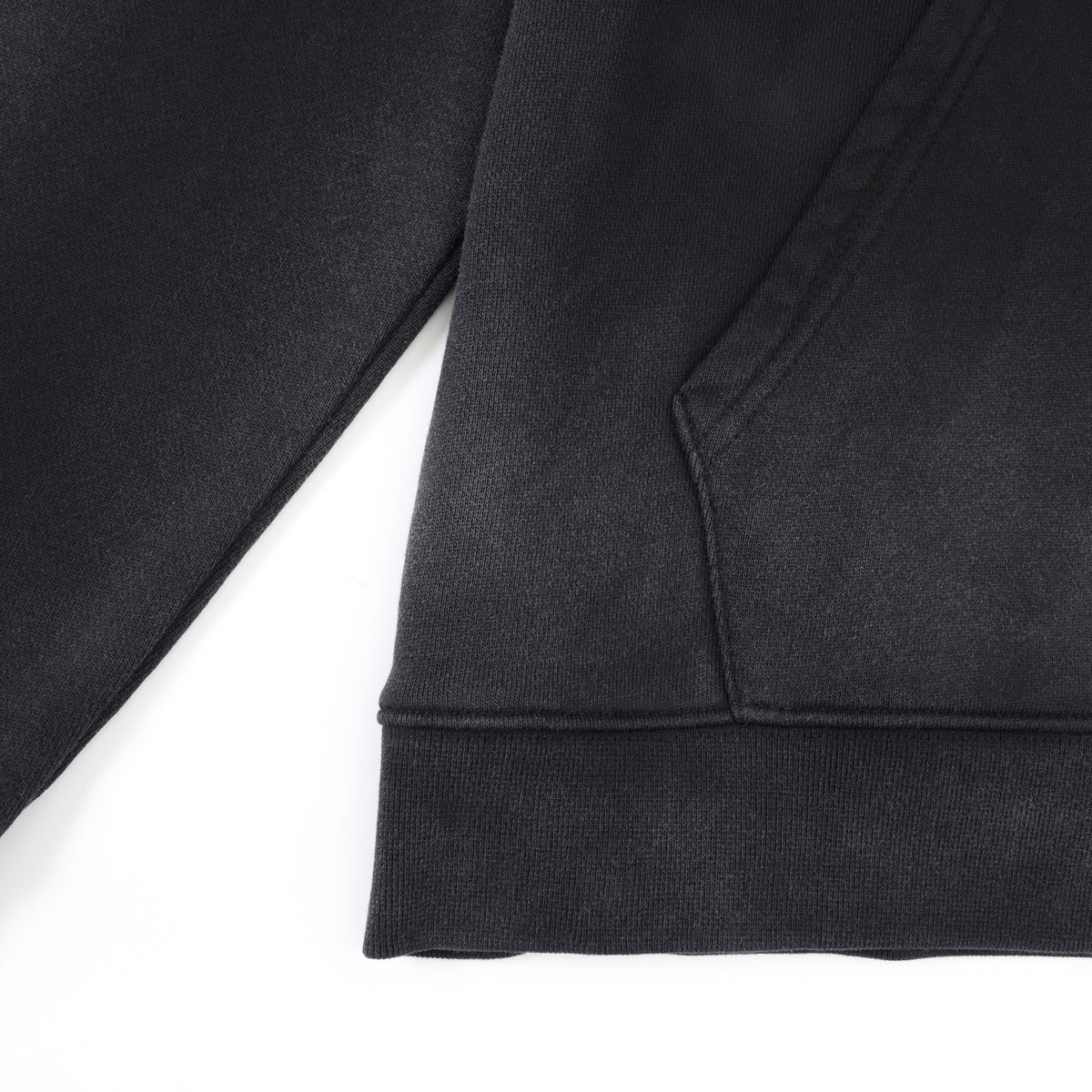 League Hoodie – Black – Close-up of kangaroo pocket seam and ribbed bottom hem