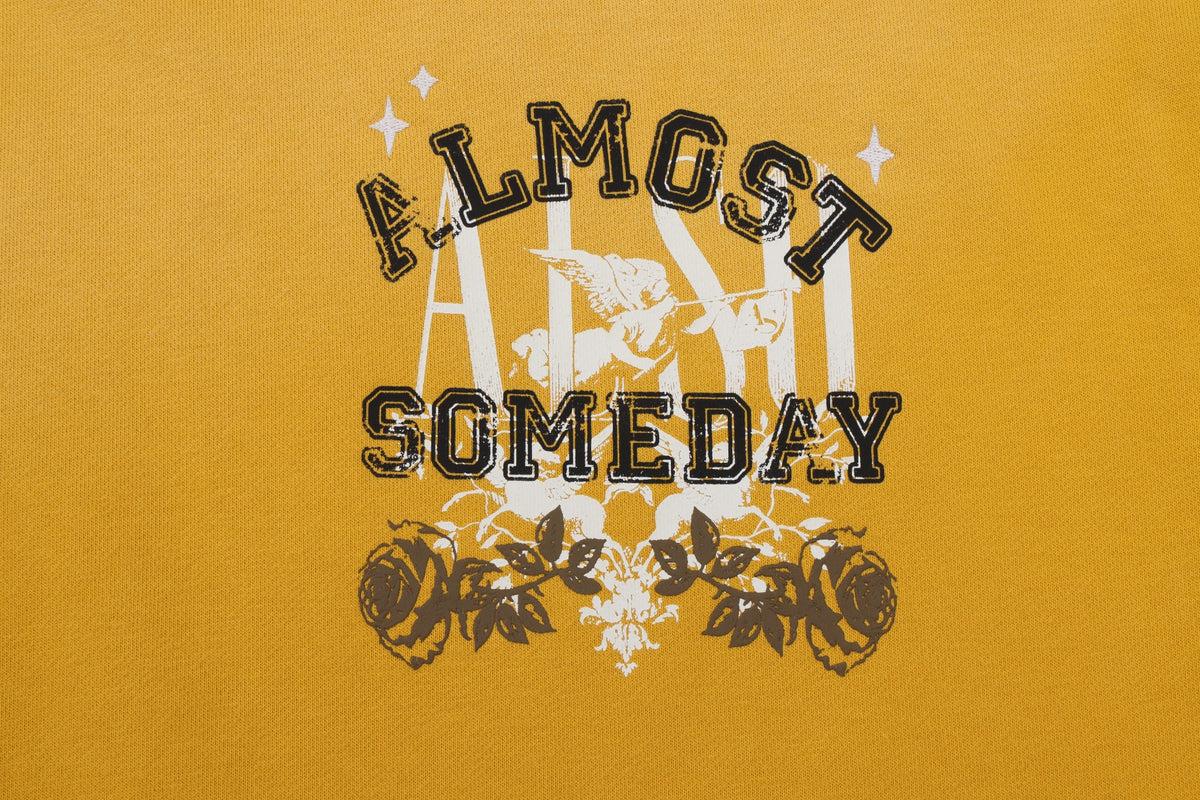League Hoodie – Yellow – Close-up of chest graphic with black lettering, white cherub, and roses