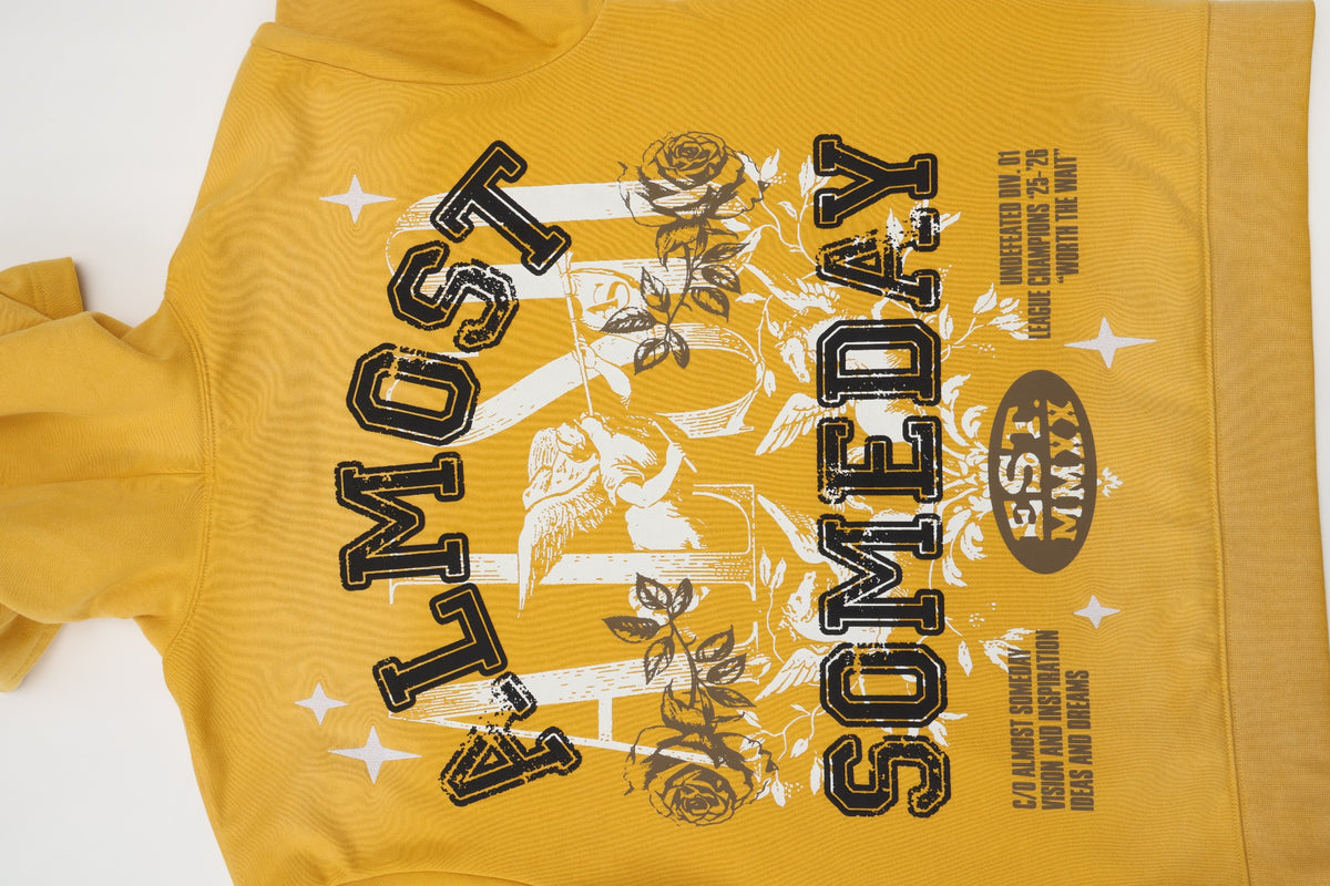 League Hoodie – Yellow – Close-up of back graphic with black ALMOST SOMEDAY lettering and white cherub artwork