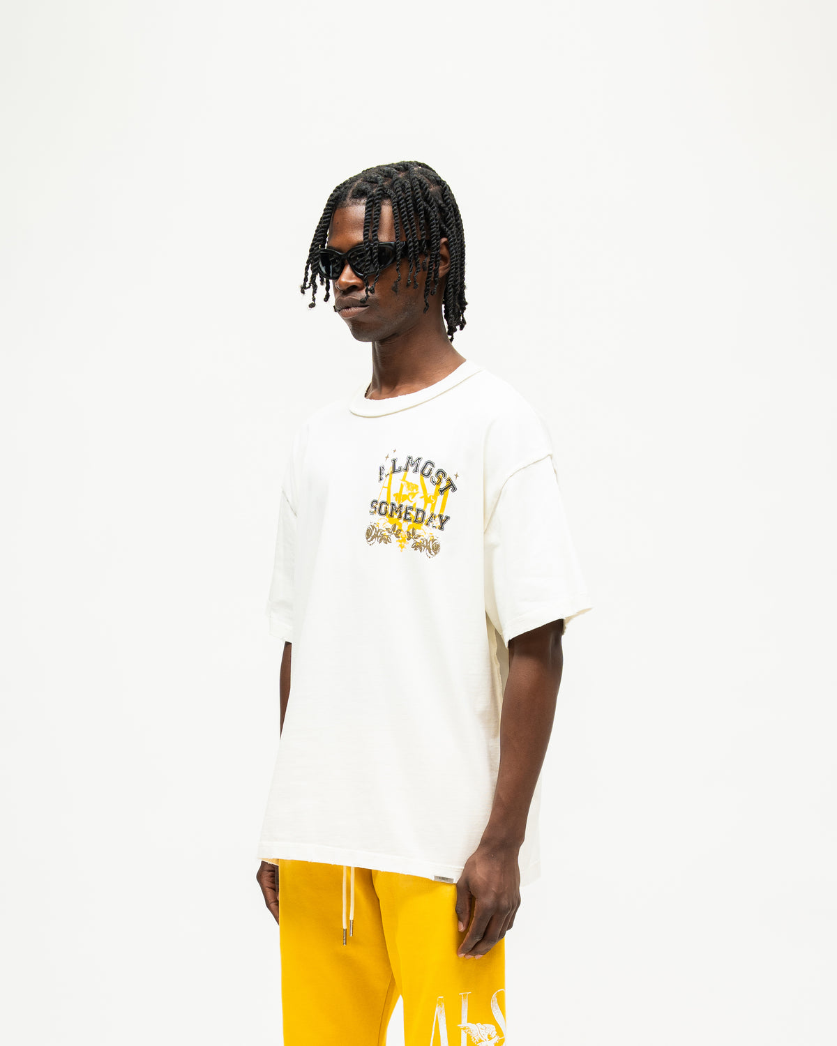 League Tee – Cream – Three-quarter front view on model showing chest graphic and dropped shoulders