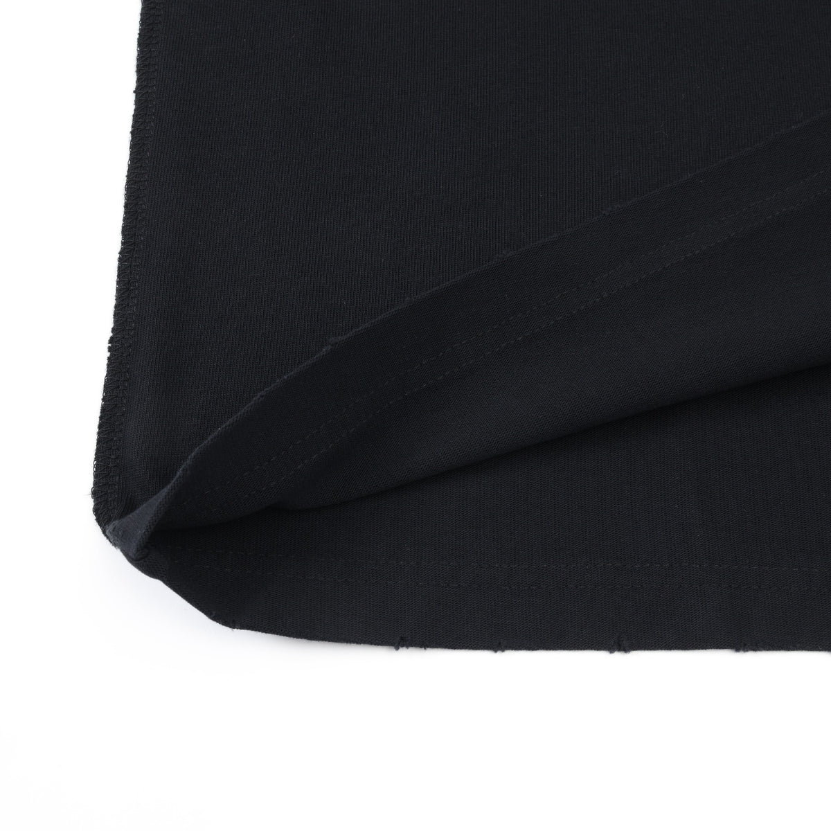 Members Tee – Black – Close-up of folded bottom hem and distressed fabric edge