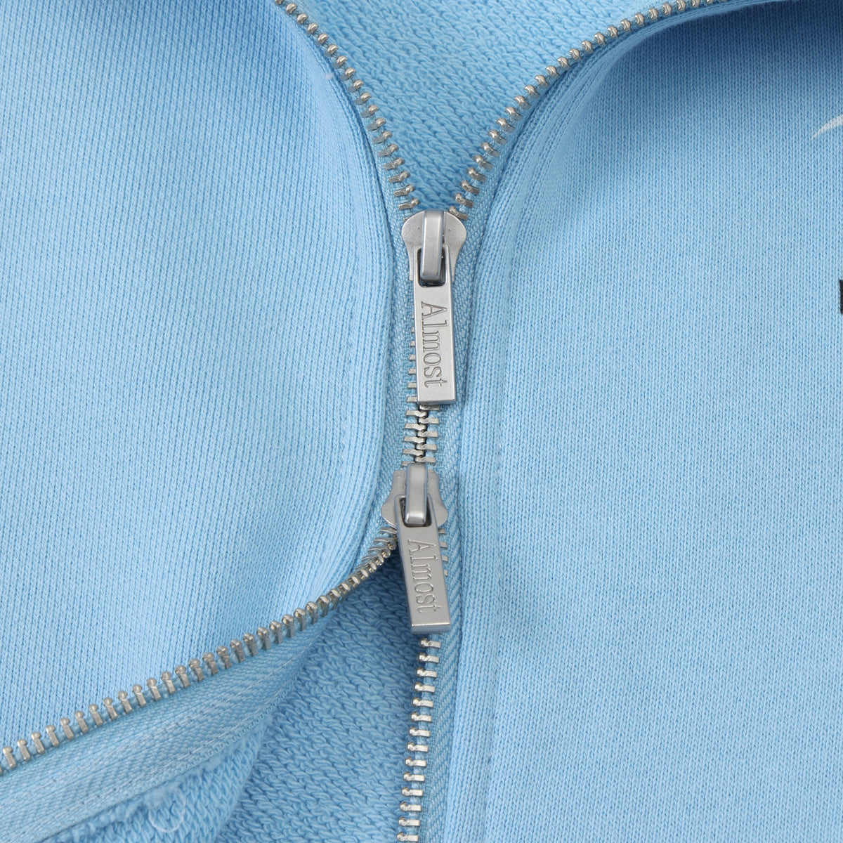 Members Zip Hoodie – Light Blue – Close-up of two-way zipper with branded metal pulls