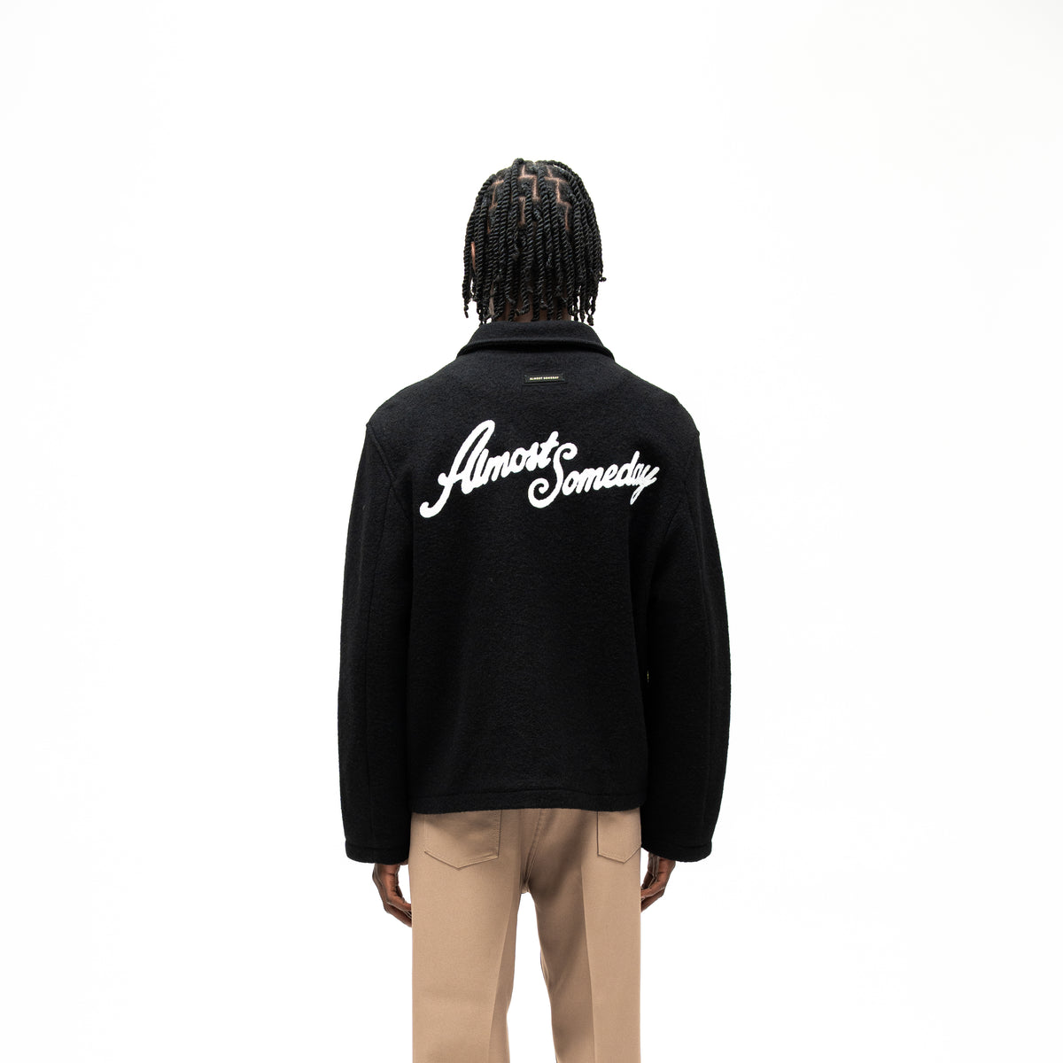 Saint Cropped Wool Jacket – Black – Back view on model showing large white Almost Someday script and small label beneath collar
