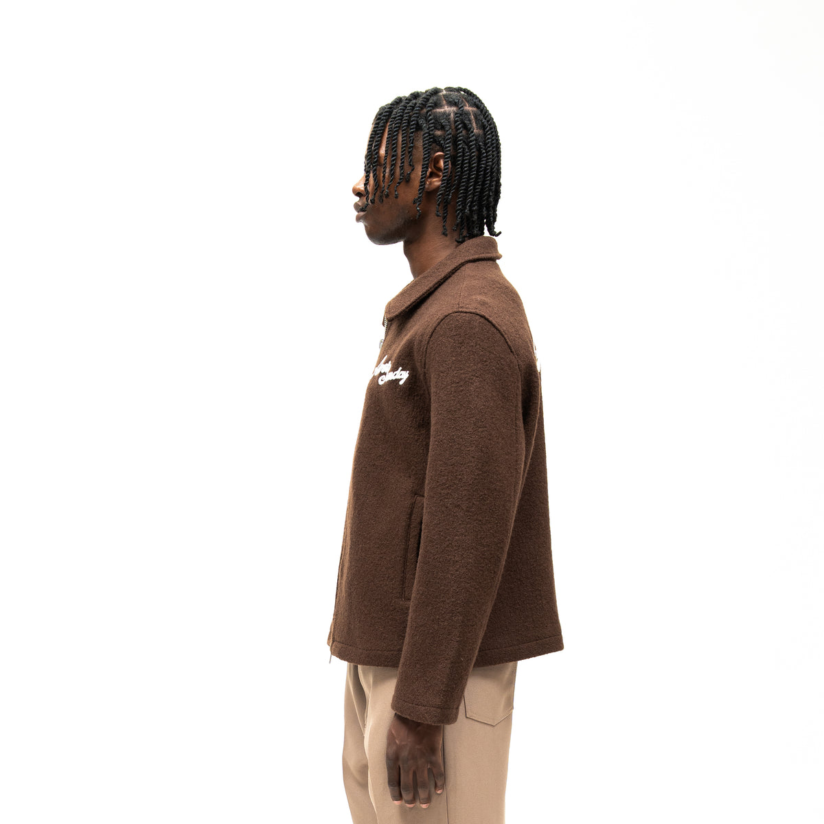Saint Cropped Wool Jacket – Brown – Side view on model showing pointed collar, long sleeve, side pocket, and textured fabric