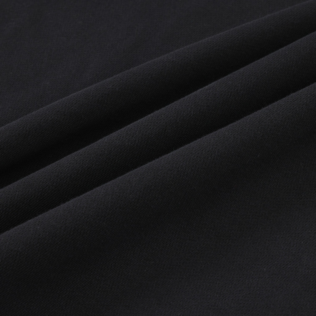 Smoke Crewneck – Black – Close-up of black fabric arranged in folds