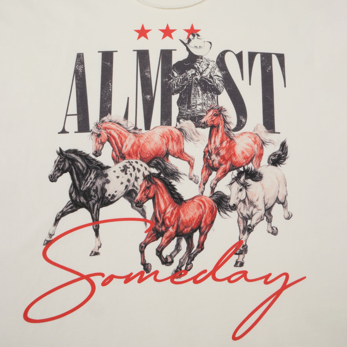 Smoke Tee – Cream – Close-up of cowboy and running horses artwork with black Almost lettering and red Someday script