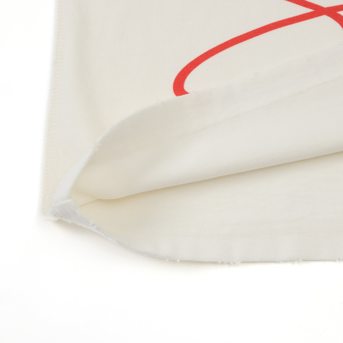 Smoke Tee – Cream – Close-up of folded hem showing inside fabric and partial red script