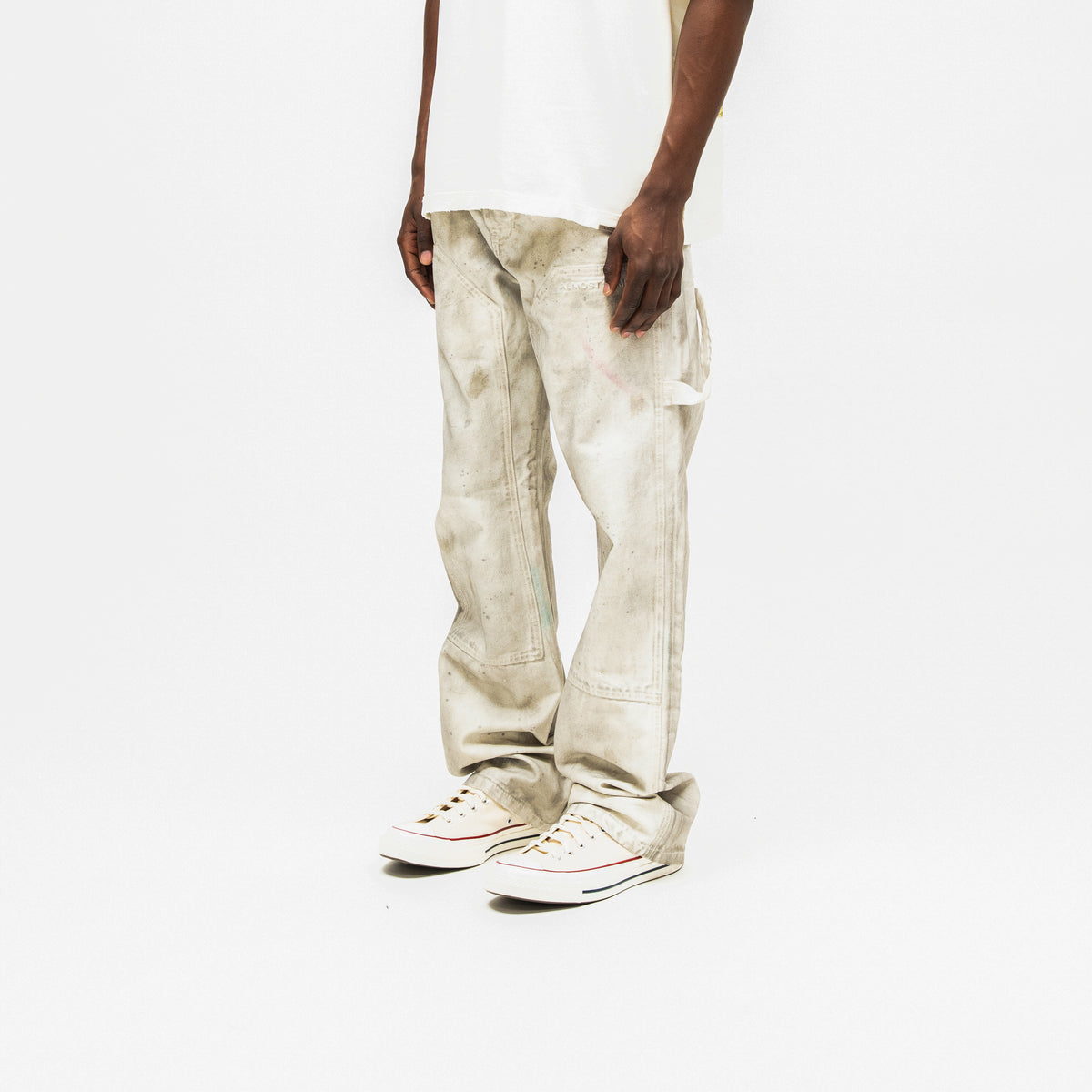 Spade Pants – Cream – Three-quarter front view on model styled with white tee, showing paneled legs and side utility loop