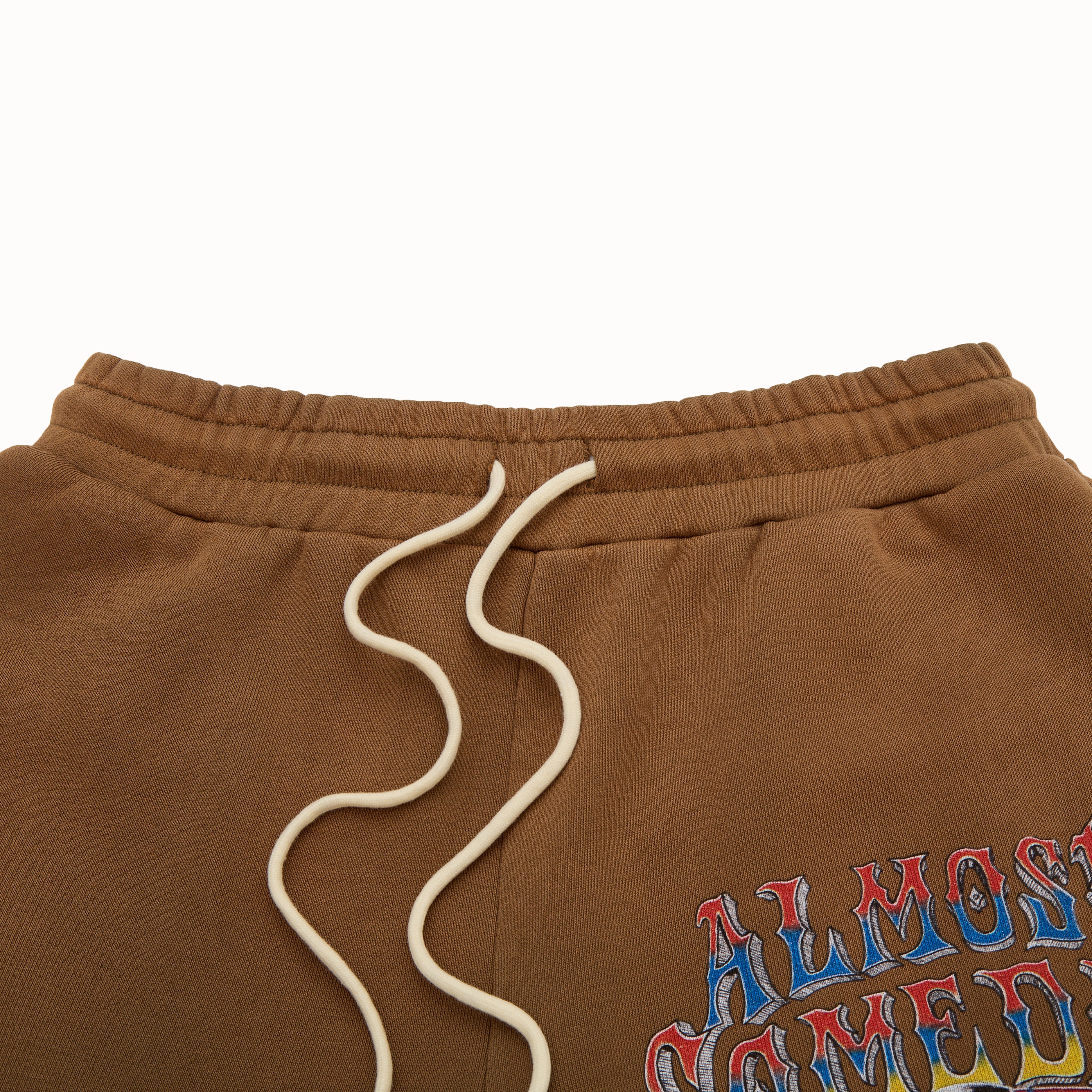 Brown sweatshorts with a colorful text design on a white background