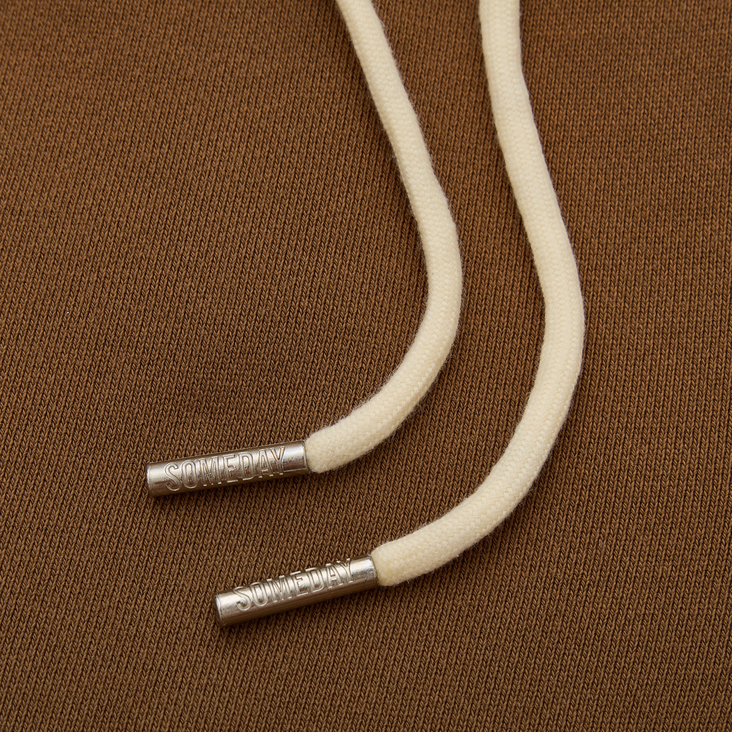 White cord with metal ends on a brown textured background
