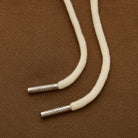 White cord with metal ends on a brown textured background