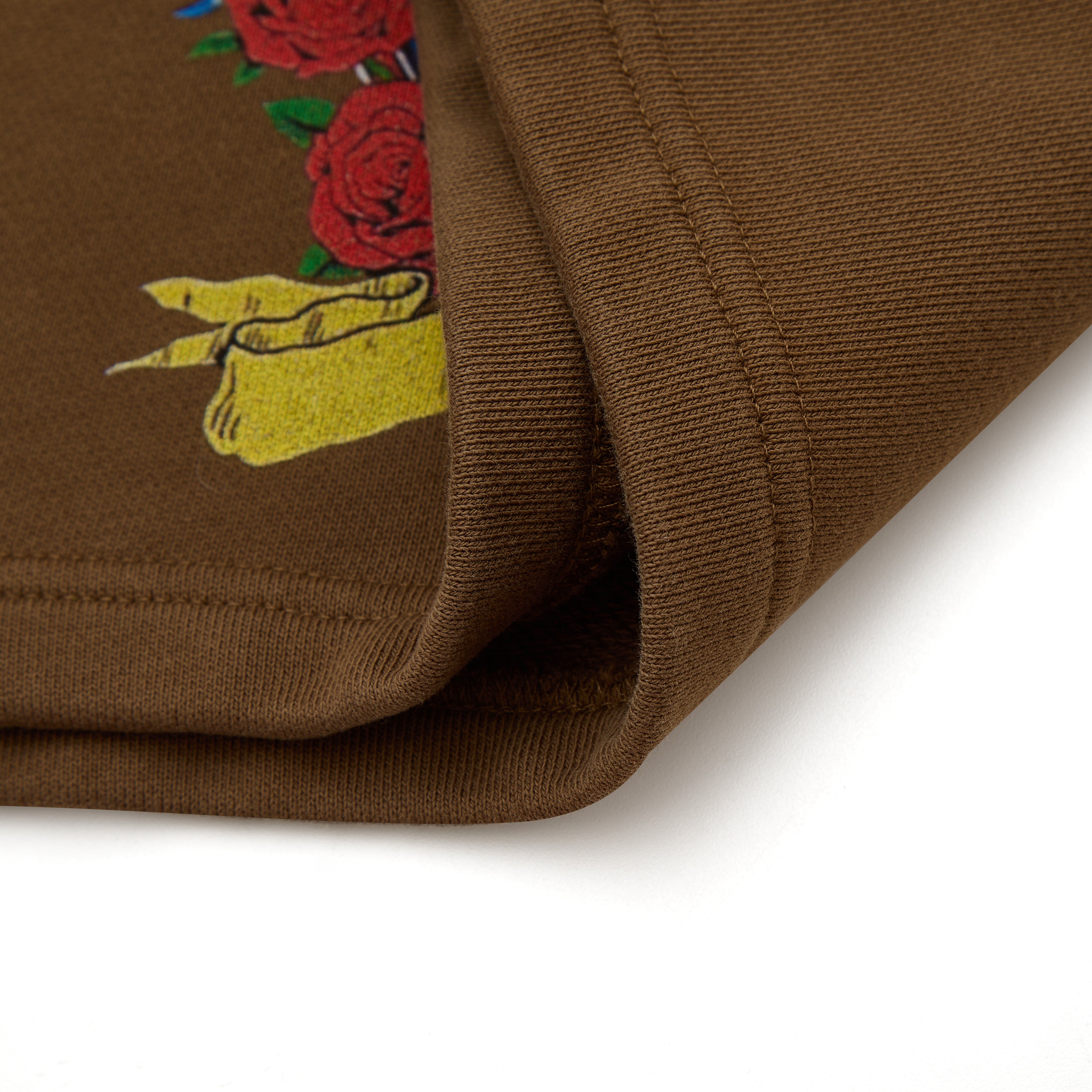 Brown fabric with embroidered design of roses on a white background
