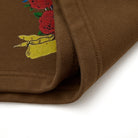 Brown fabric with embroidered design of roses on a white background