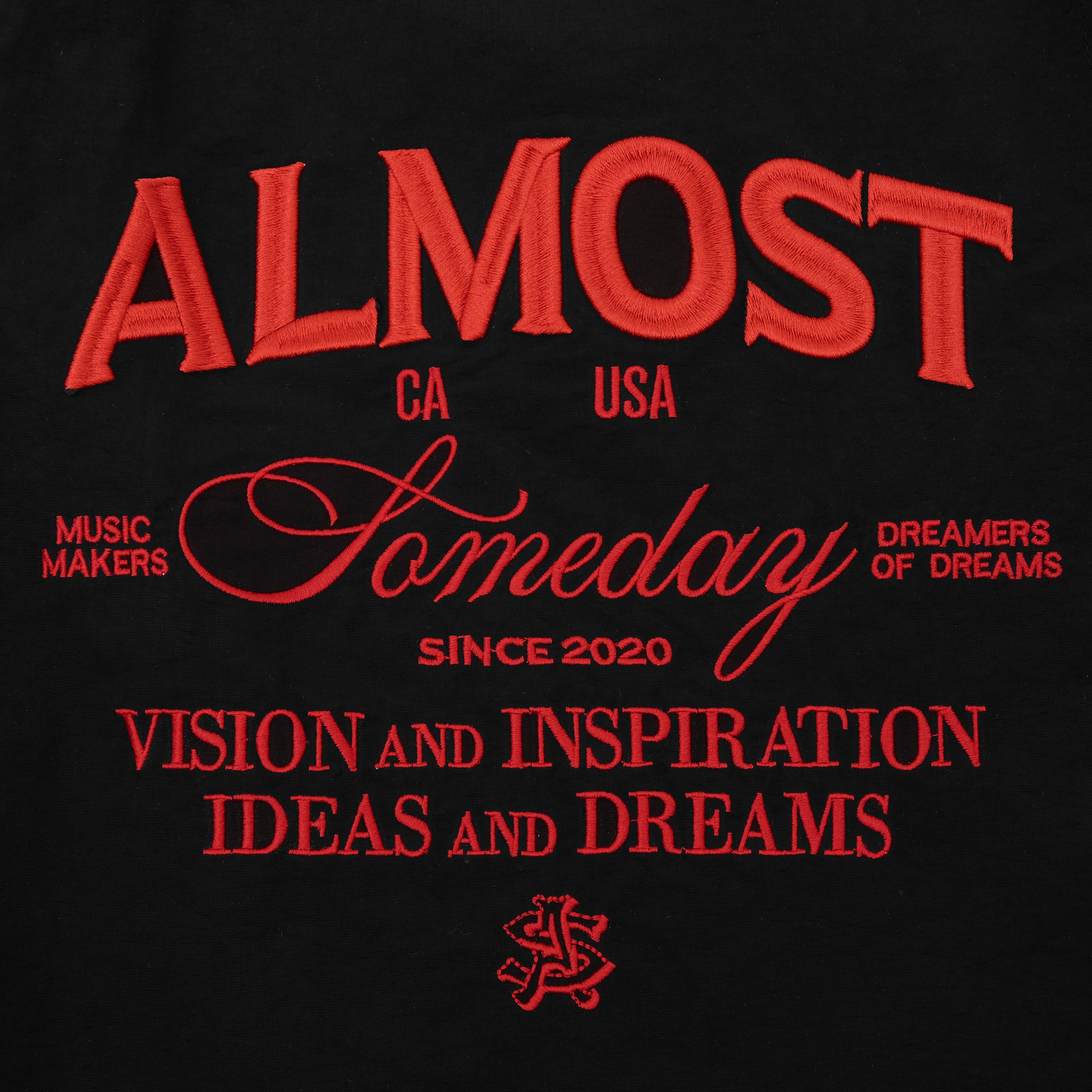 Black shorts with red ALMOST SOMEDAY text and branding on a black background