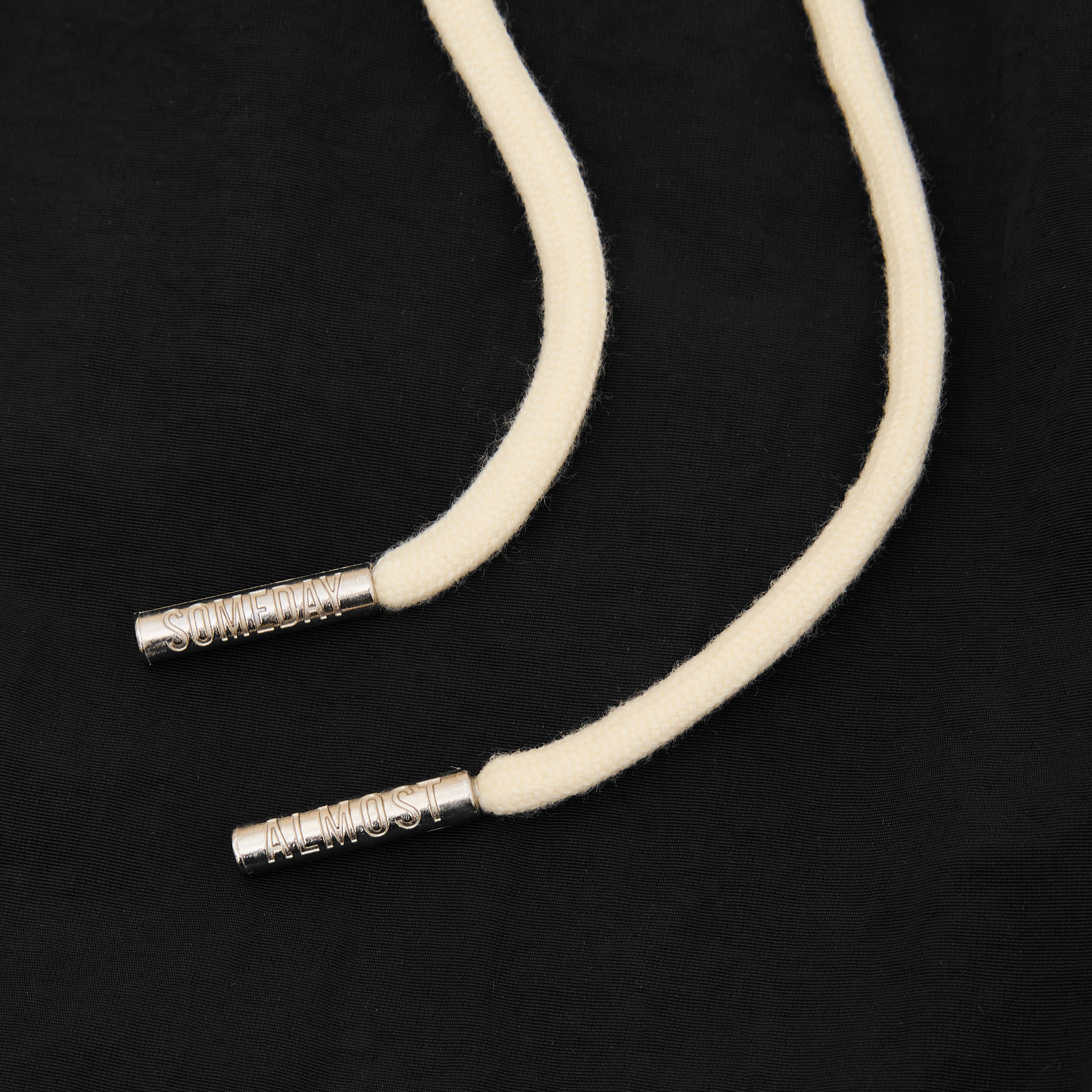 Beige cord with silver ends on a black background