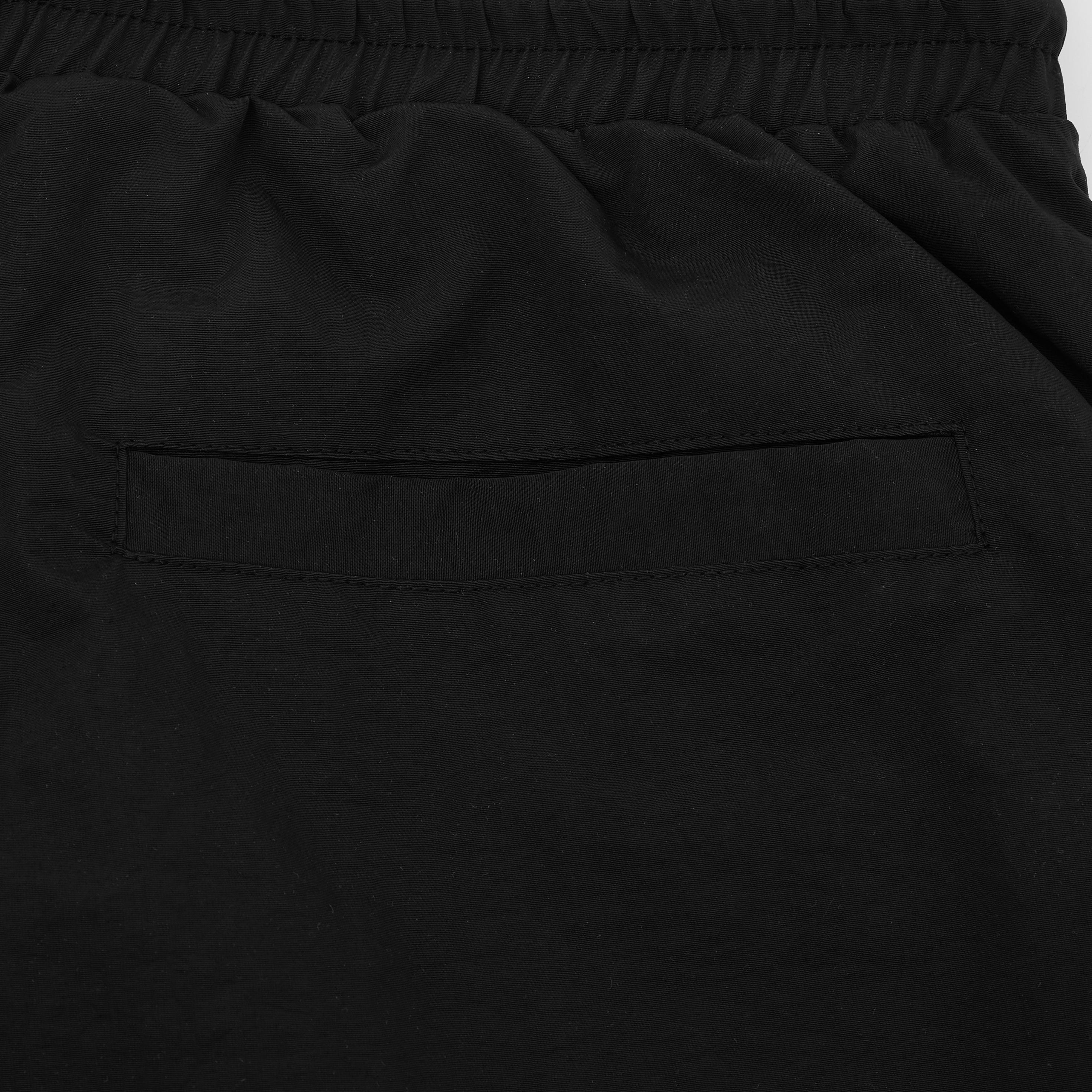 Close-up of black pants with a pocket on a light gray background