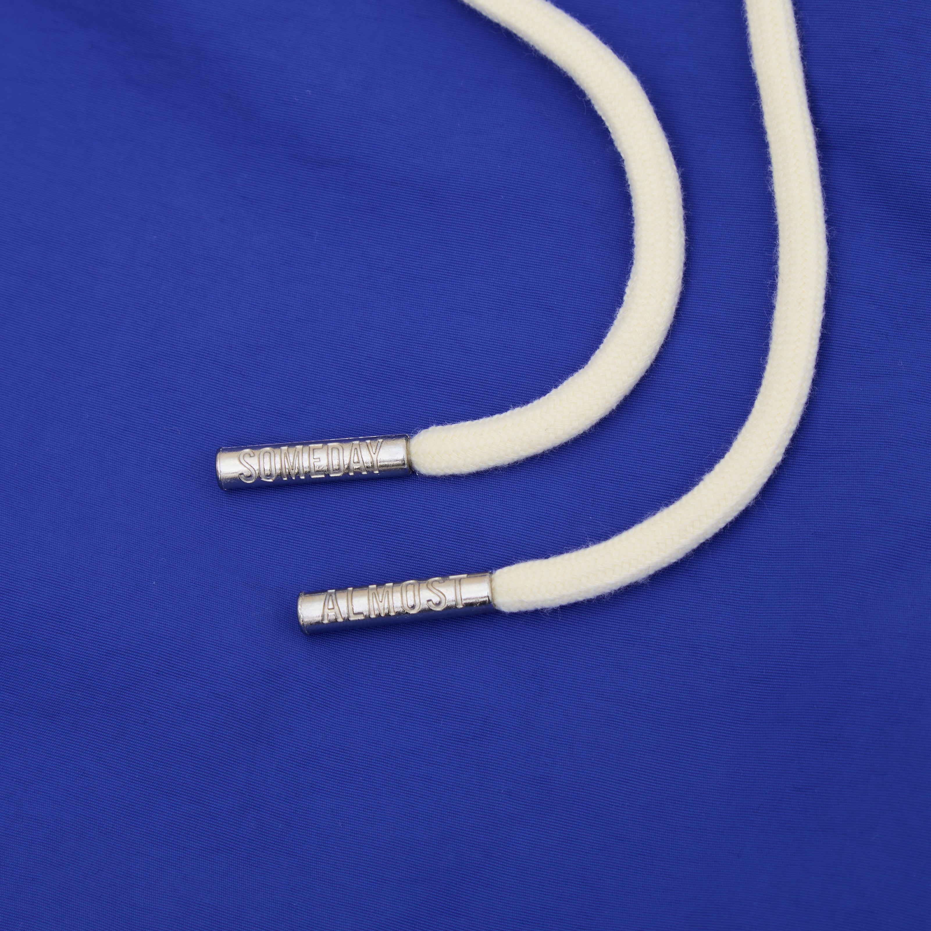 White cord with silver ends on a blue background