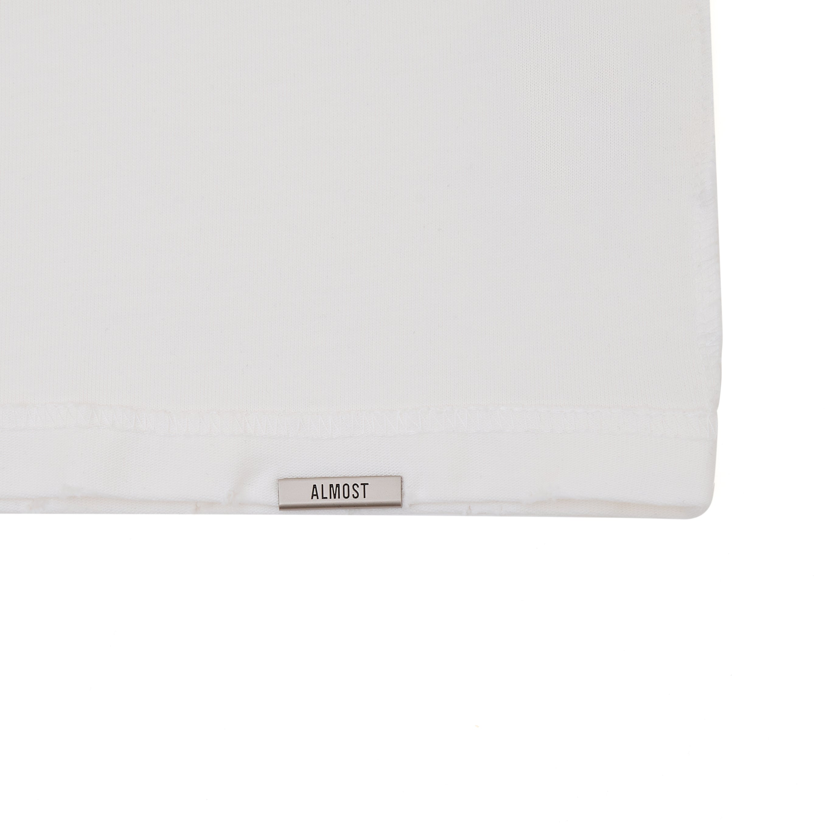 White pillow with 'ALMOST' label on a white background