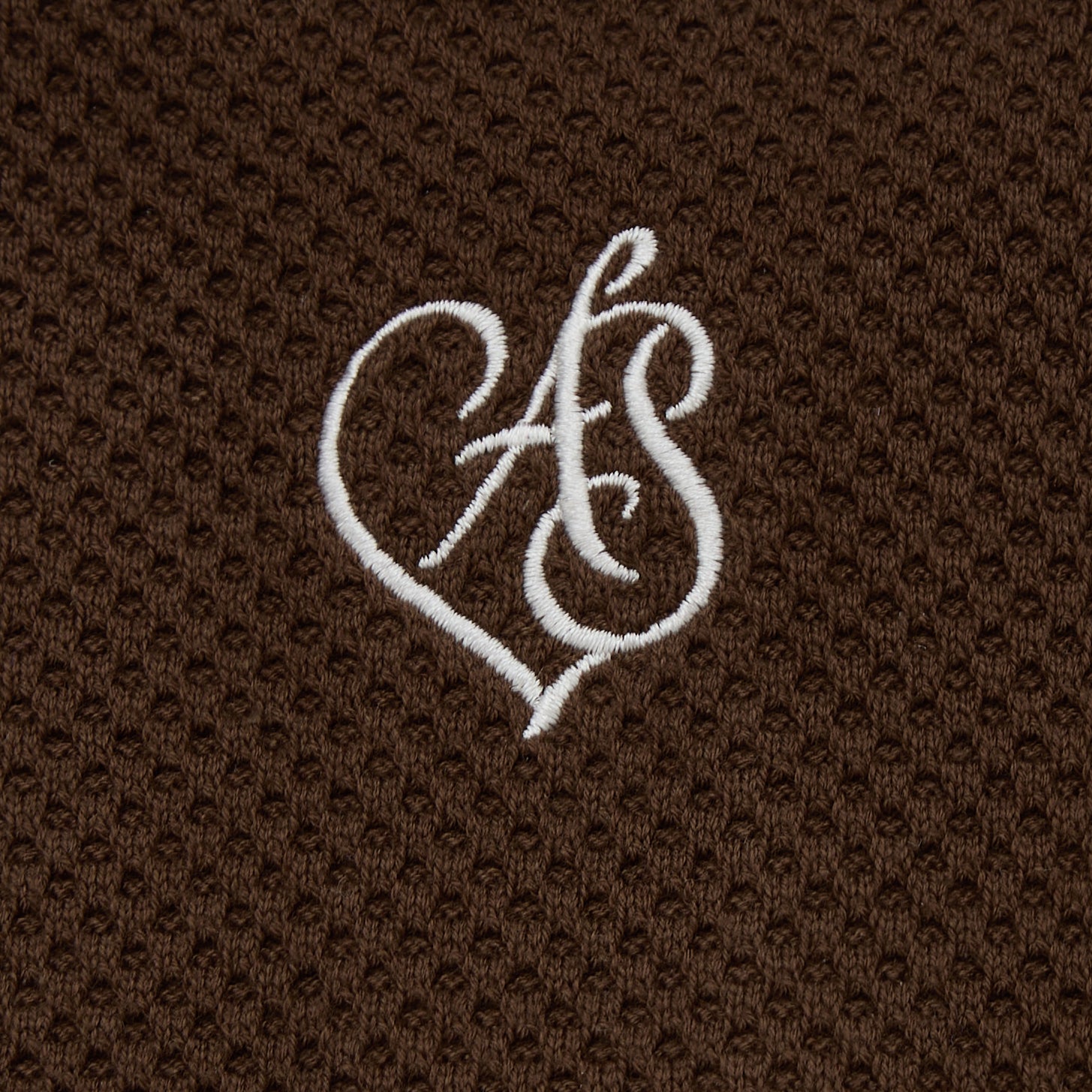 White monogram on a brown textured fabric background