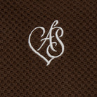 White monogram on a brown textured fabric background