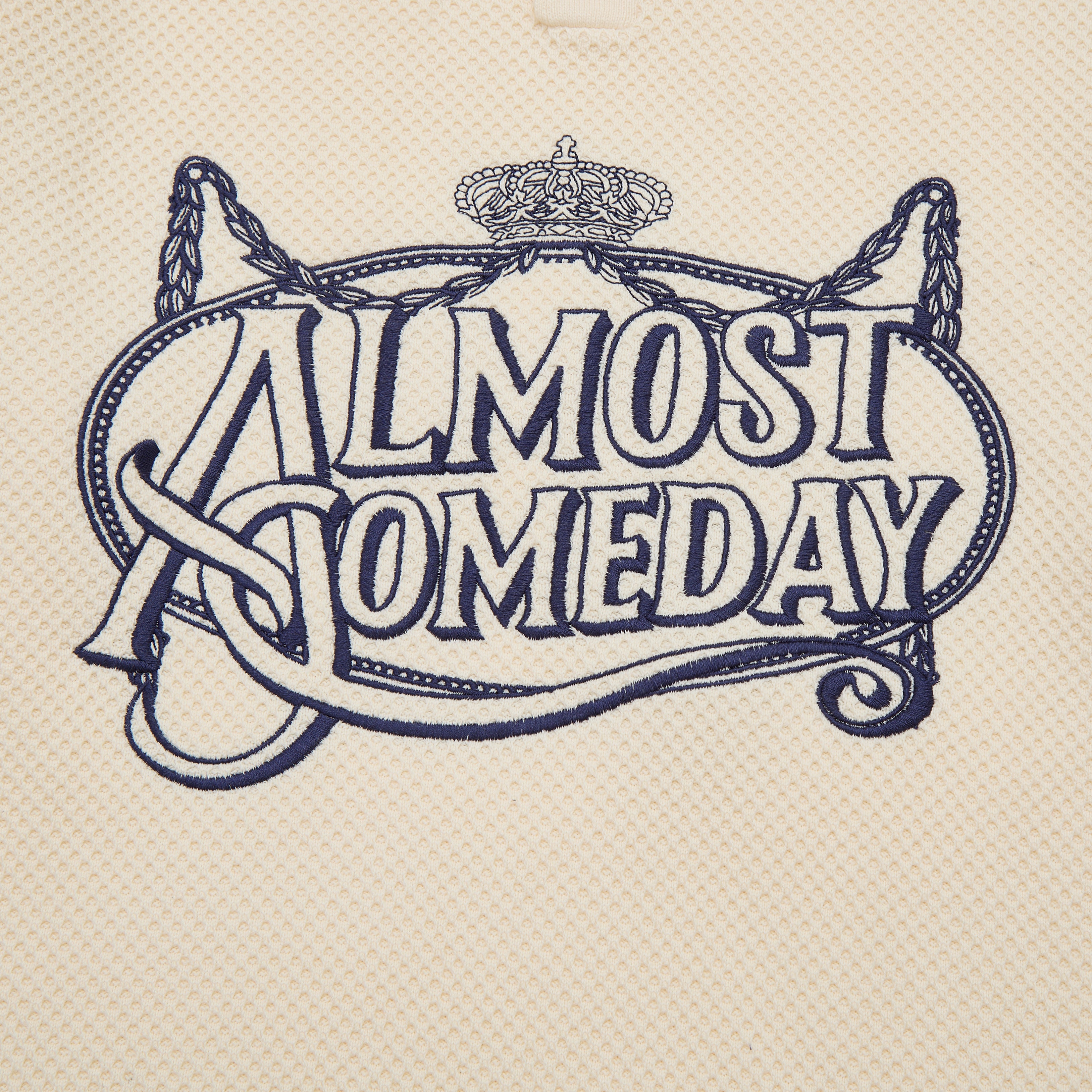 Decorative text 'ALMOST SOMEDAY' with a crown and decorative elements on a textured beige background.