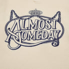 Decorative text 'ALMOST SOMEDAY' with a crown and decorative elements on a textured beige background.